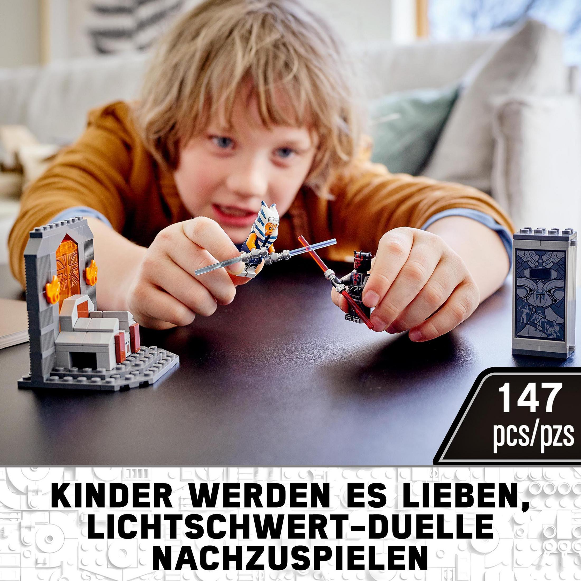 Ein Junge spielt mit Star Wars Lego. Zwei Figuren mit Lichtschwertern stehen sich gegenüber.