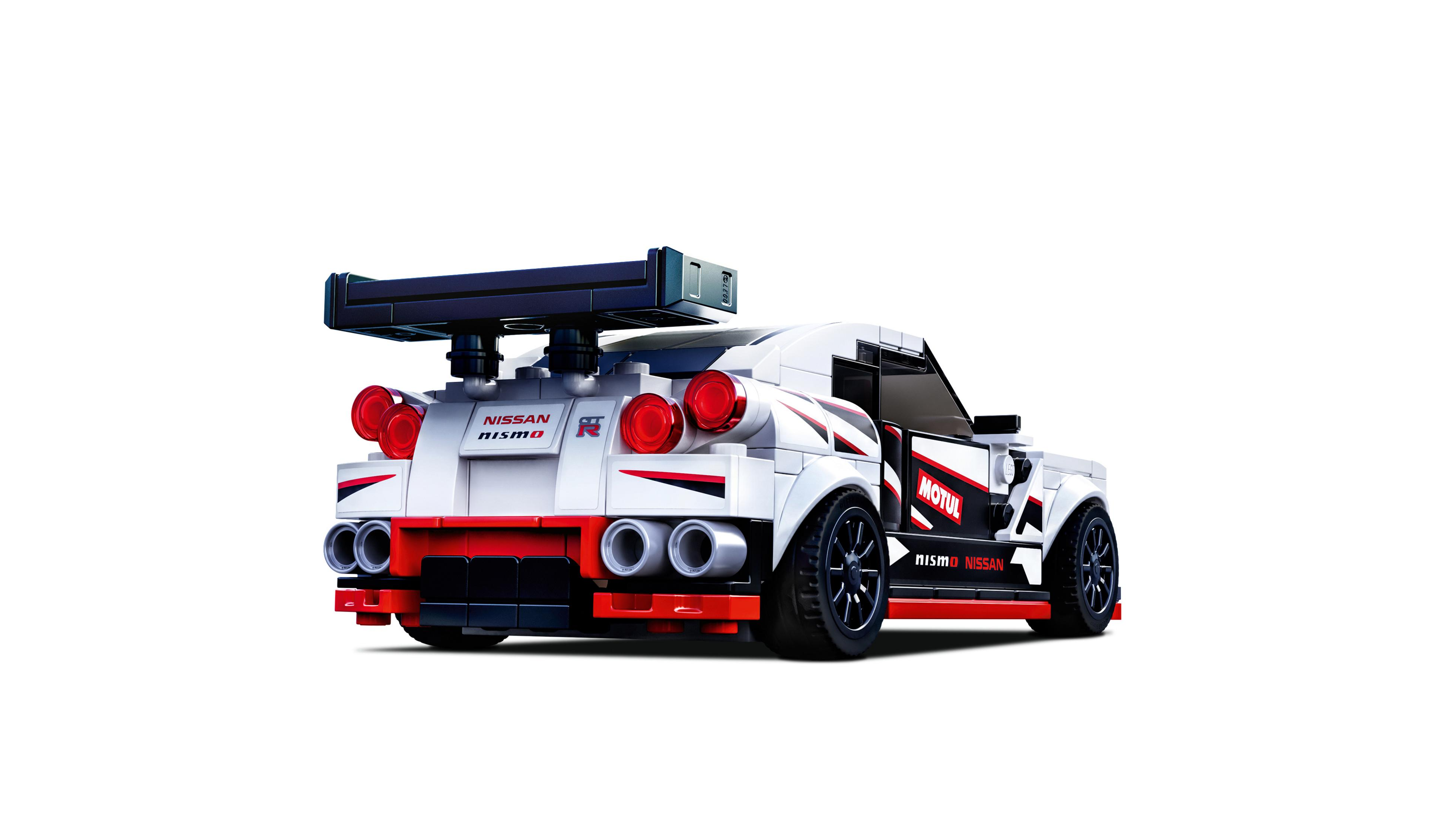 Un'auto da corsa Lego Nissan bianca e rossa con alettone posteriore, su sfondo bianco.