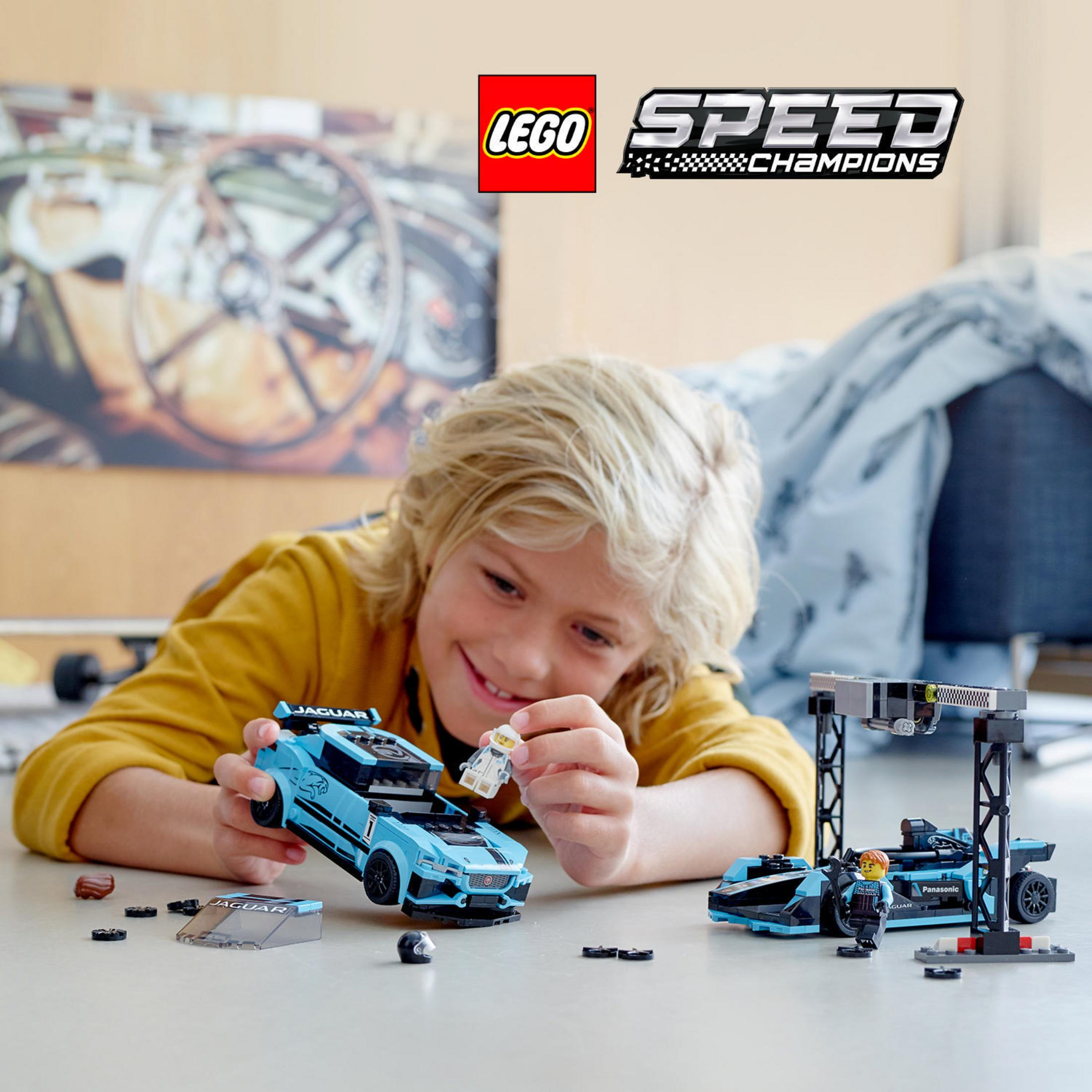 Un ragazzo gioca con un set Lego Speed Champions, con una Jaguar blu e una scena di gare.