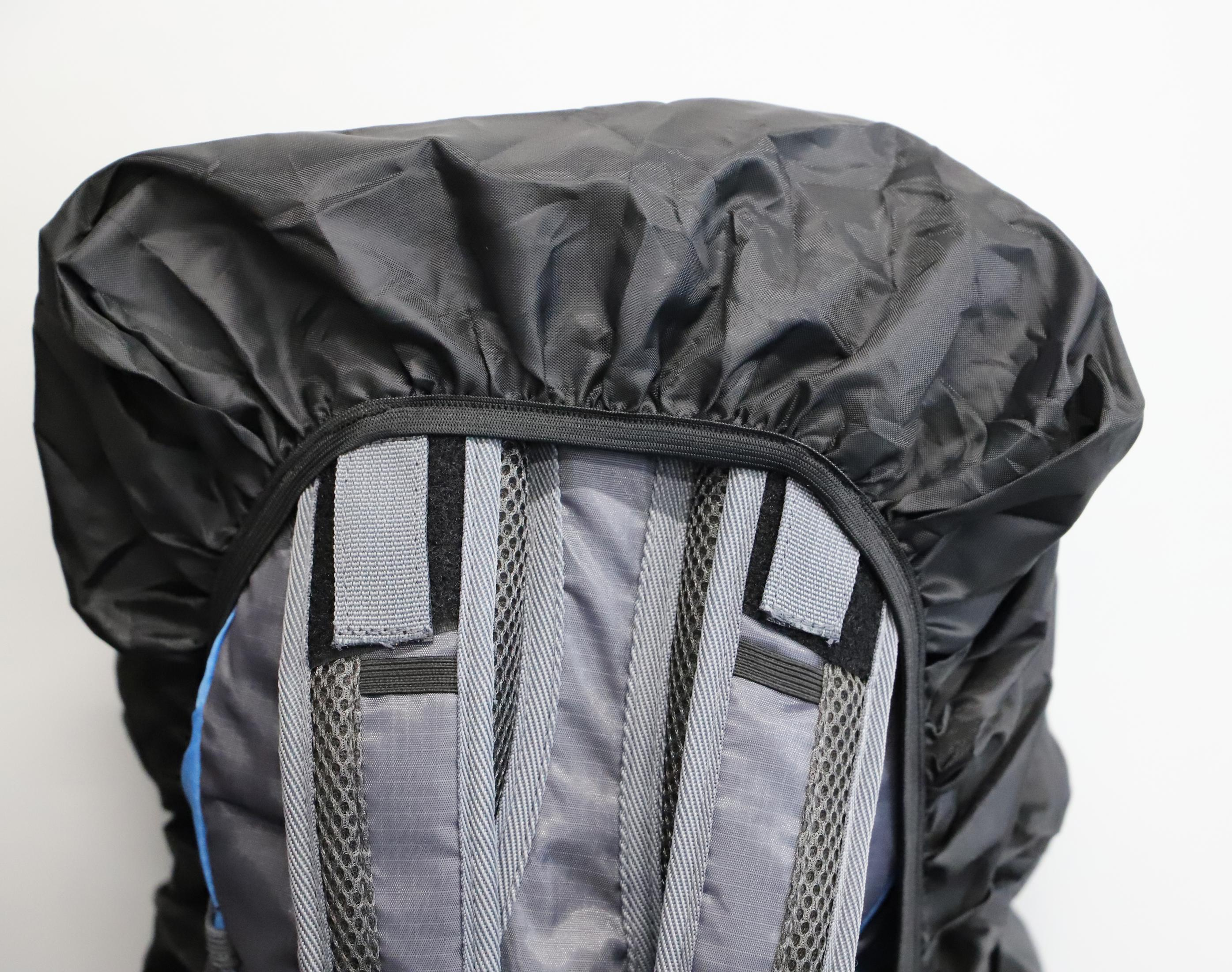 Rucksack mit schwarzem Überzug. Der Überzug ist oben. Hellgraues und blaues Material.