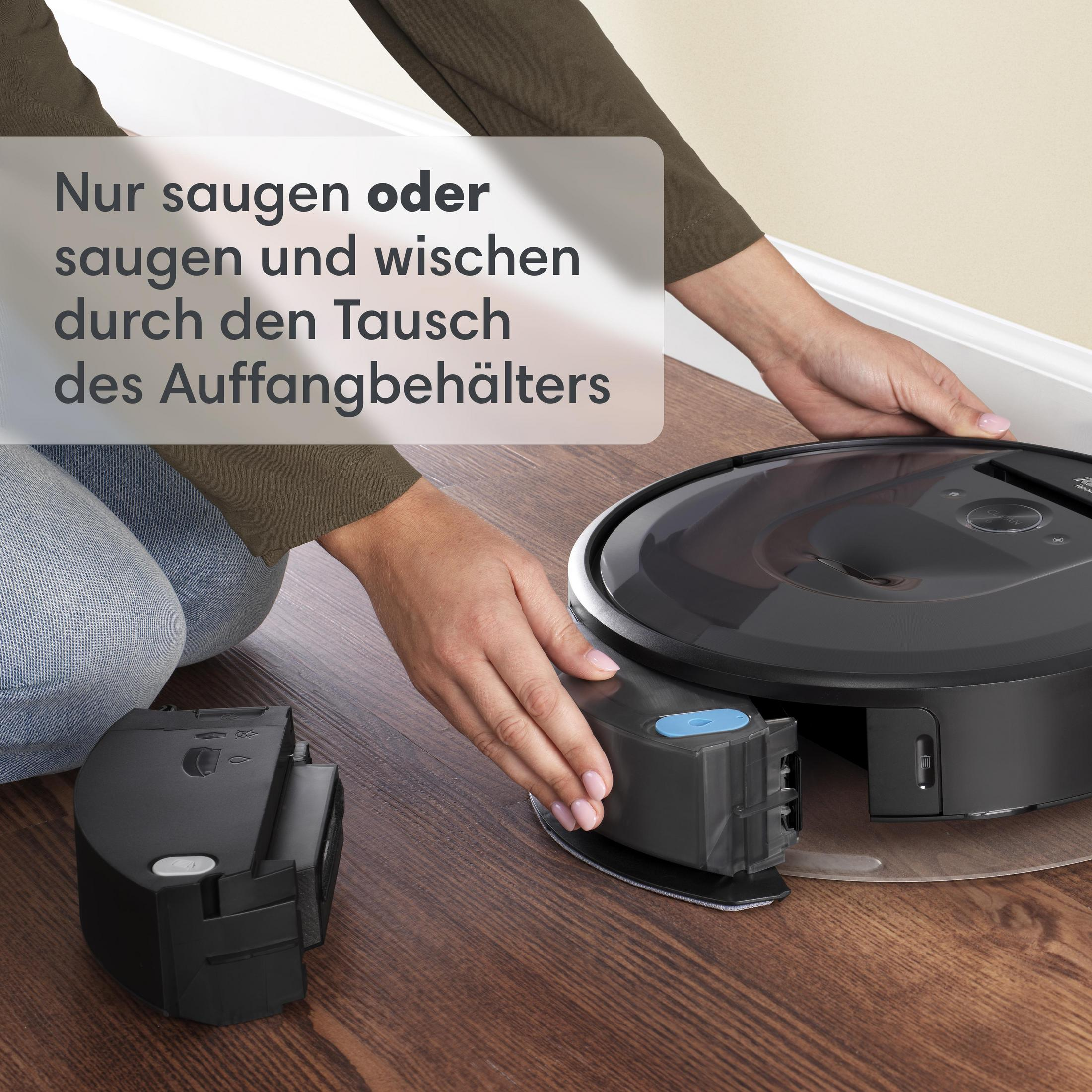 A person changing a part of robot vacuum on a wooden floor.
