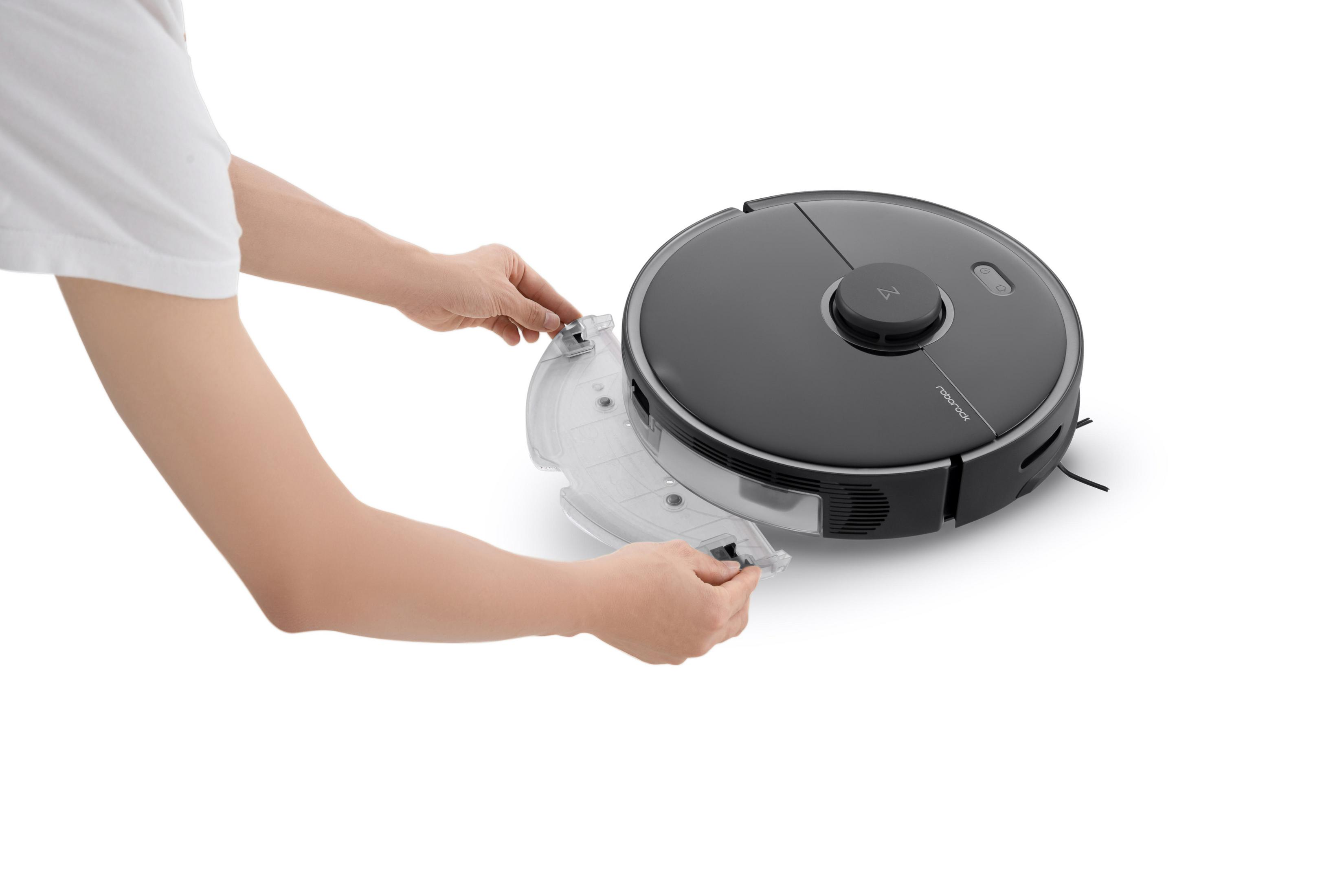 Hände entfernen den Wassertank von einem schwarzen Roboterstaubsauger.