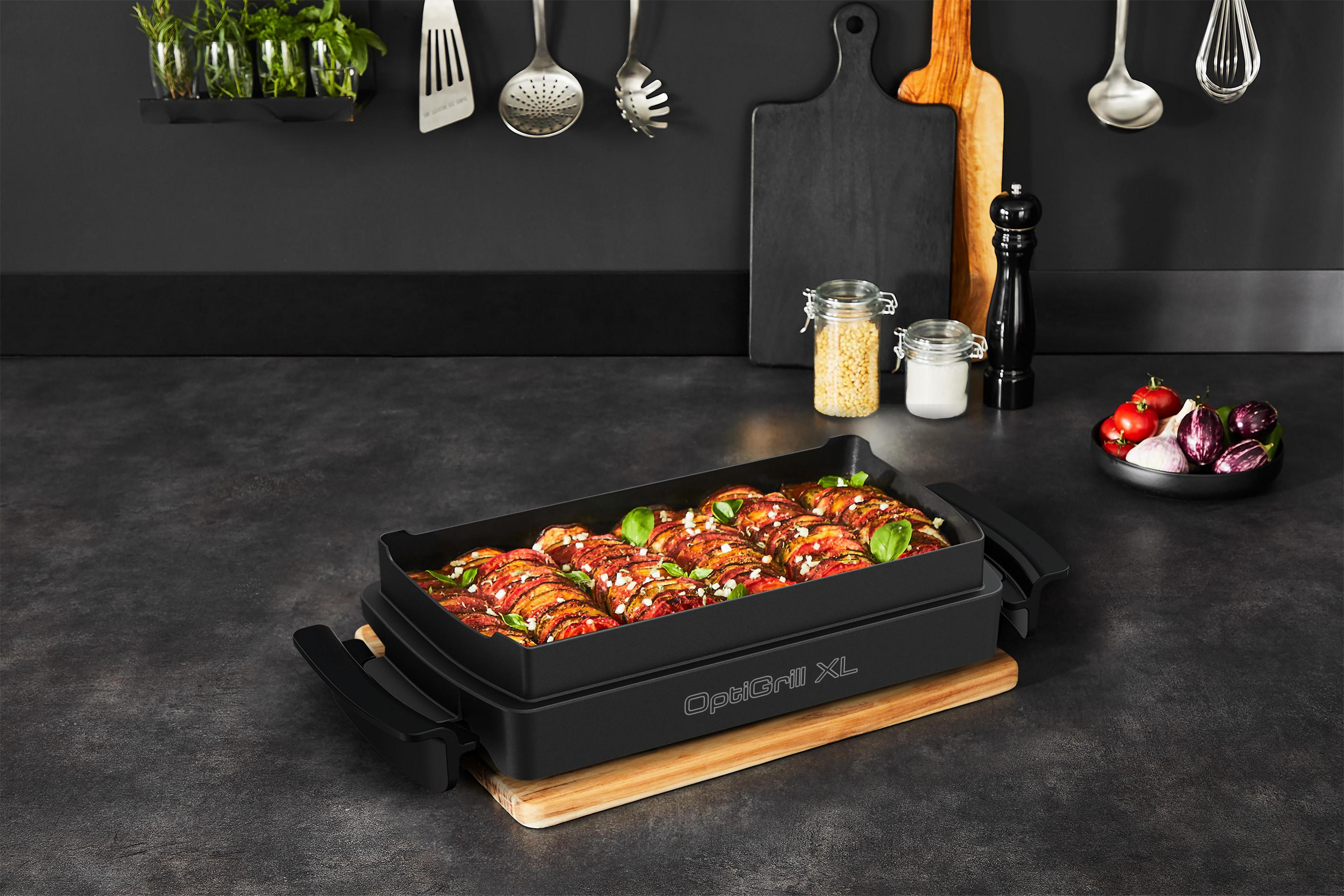 Black OptiGrill XL with cooked food. Vegetables and a wooden board are visible.