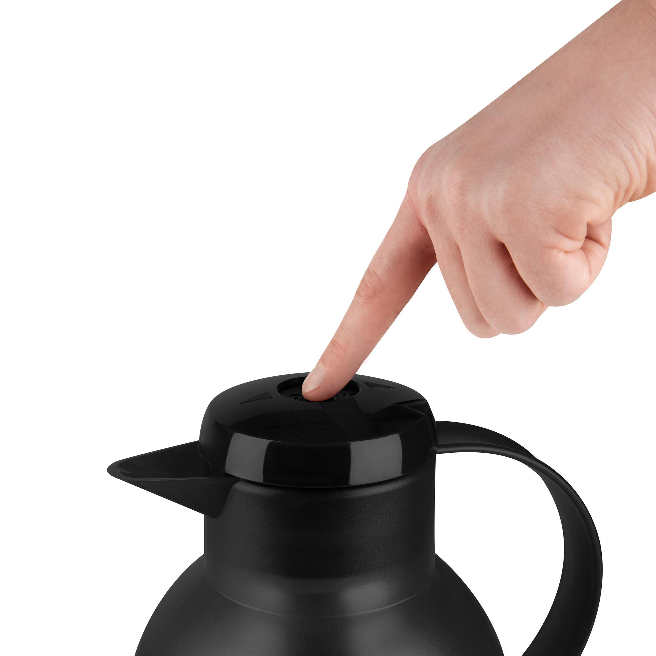 Mano che preme il pulsante del coperchio del thermos nero. Sfondo bianco.