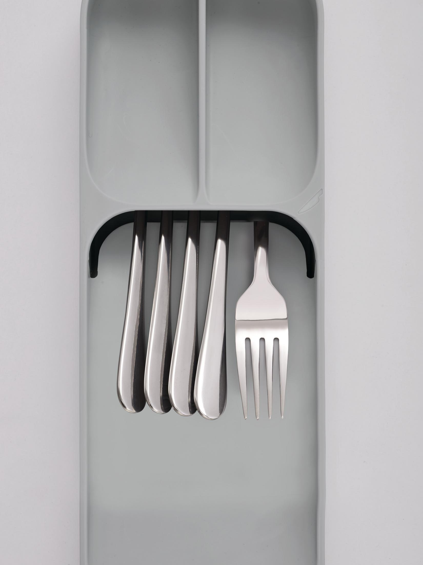 Bandeja gris para cubiertos con tenedores plateados. Seis tenedores están en la bandeja, uno está fuera. Fondo blanco.
