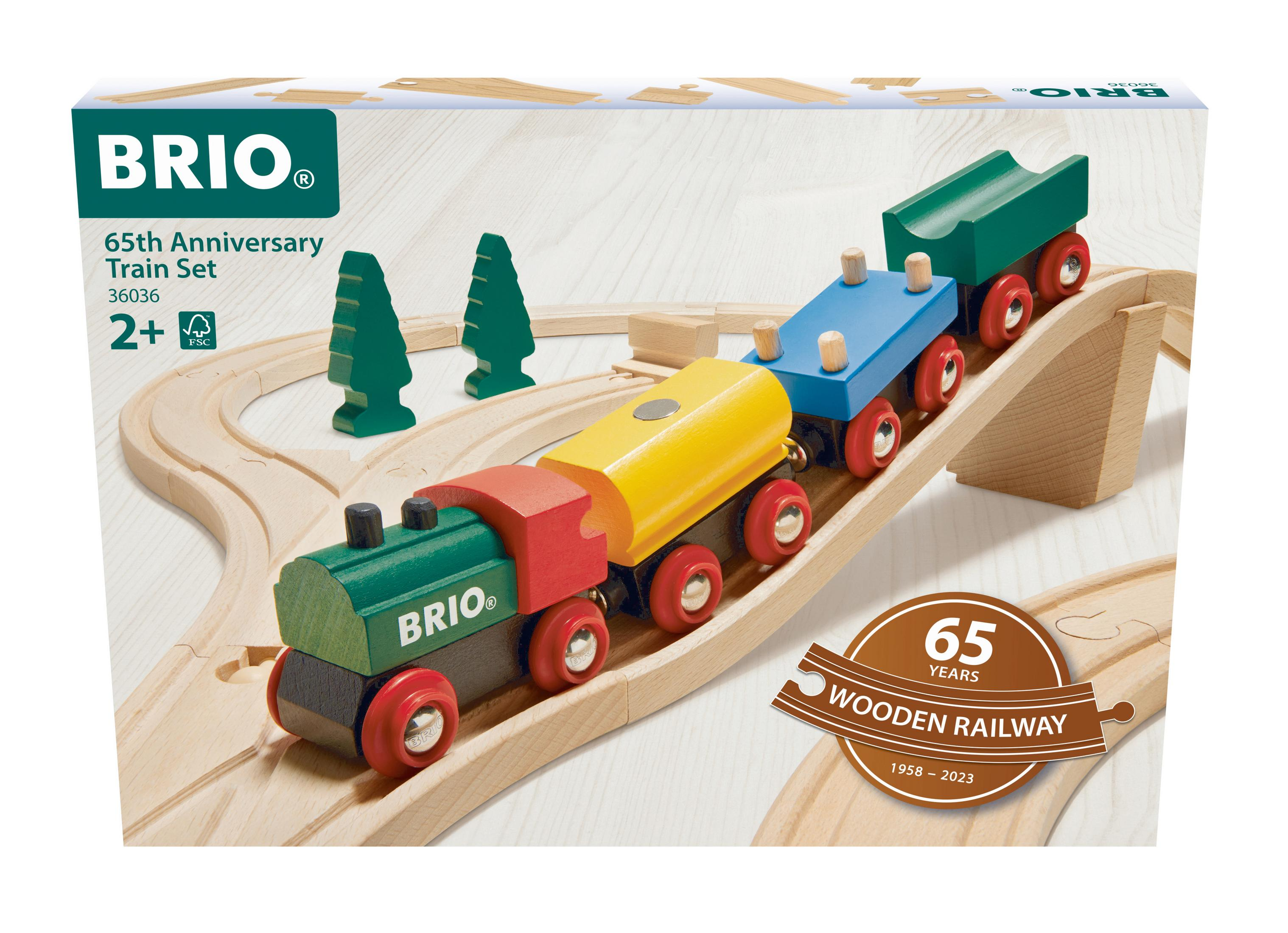 Ein hölzernes Spielzeug-Zugset mit einer grünen Lokomotive, einem roten und einem gelben Wagen auf einer Holzstrecke.