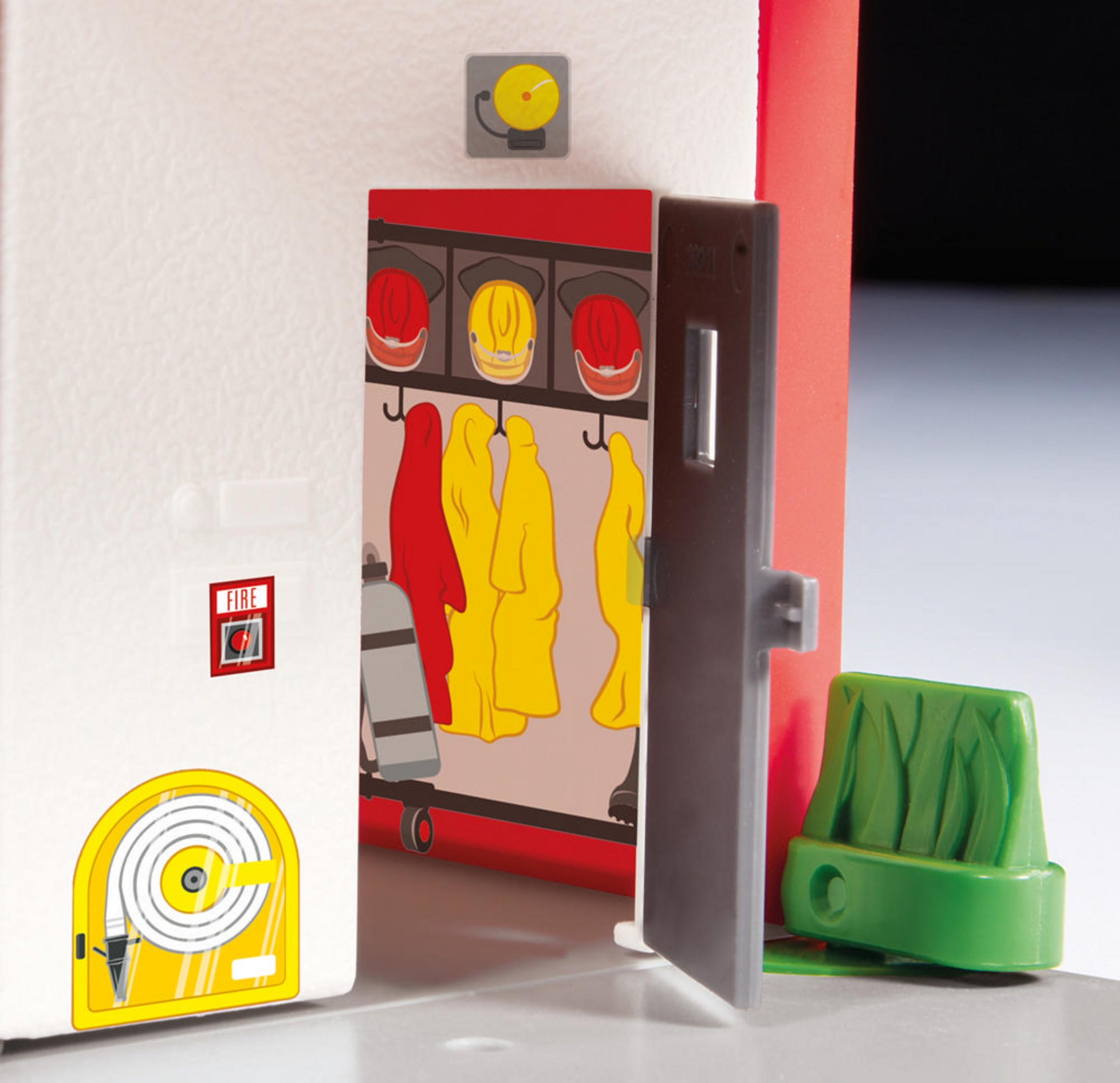 Eine Spielzeug-Feuerwehrstation. Rote und gelbe Mäntel hängen im Schrank. Ein Feuerwehrschlauch ist sichtbar.
