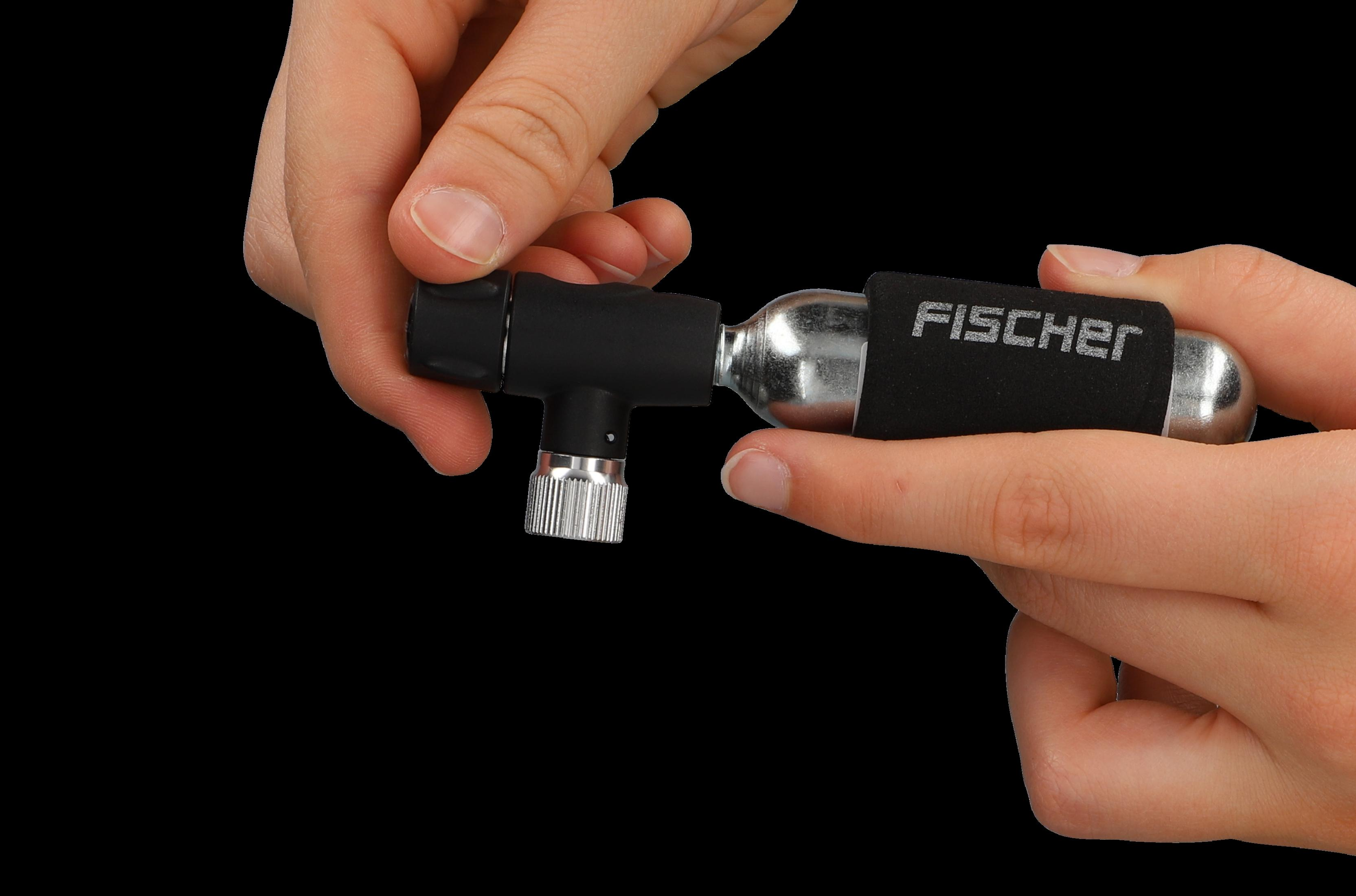 Hände halten einen schwarzen CO2-Inflator mit Fischer-Etikett und eine silberne CO2-Kartusche.