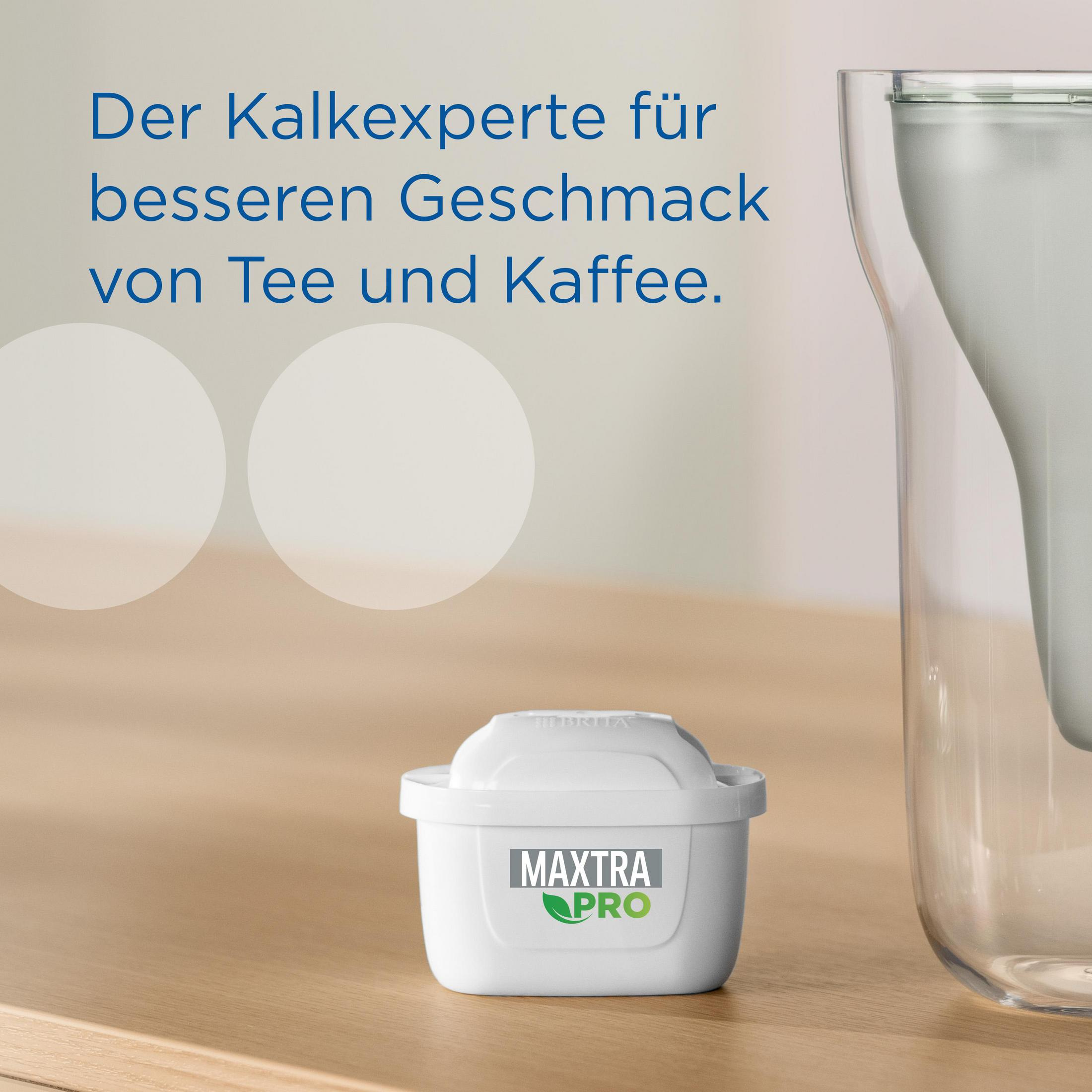 Ein Wasserfilter neben einem transparenten Krug auf einer Holzoberfläche.