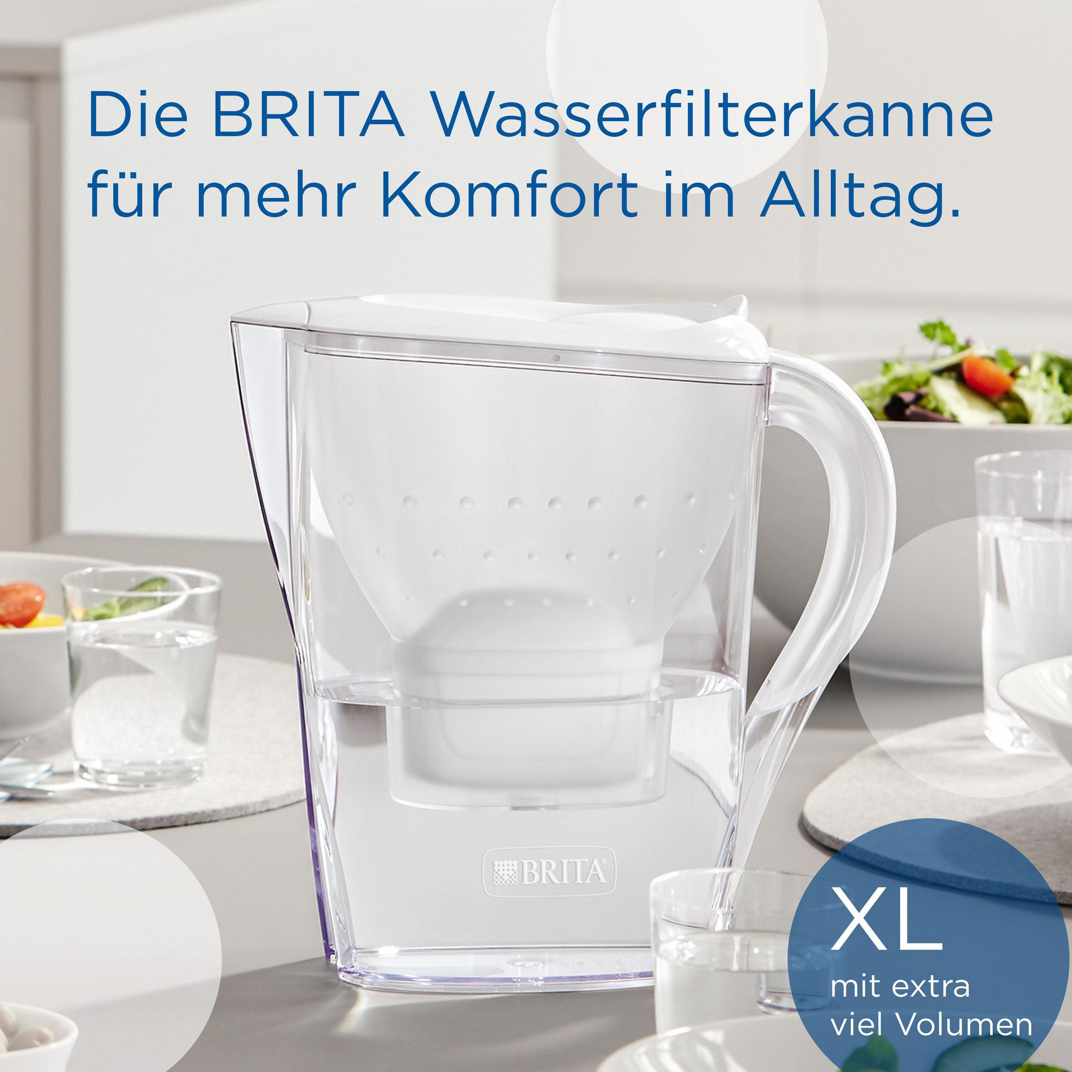 Een doorzichtige Brita waterfilterkan gevuld met water, naast glazen en een salade.