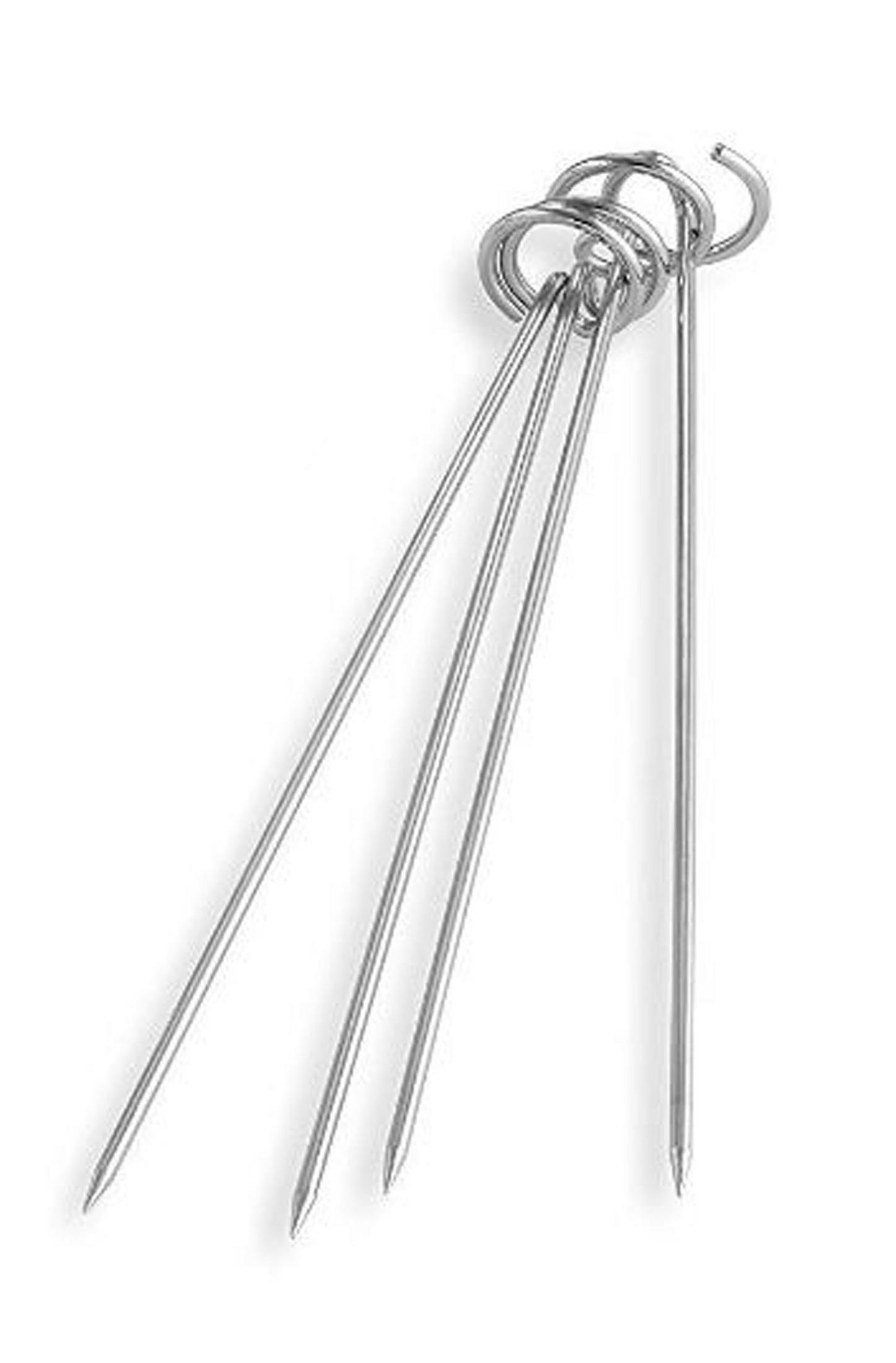 Brochetas de metal dispuestas sobre un fondo blanco.
