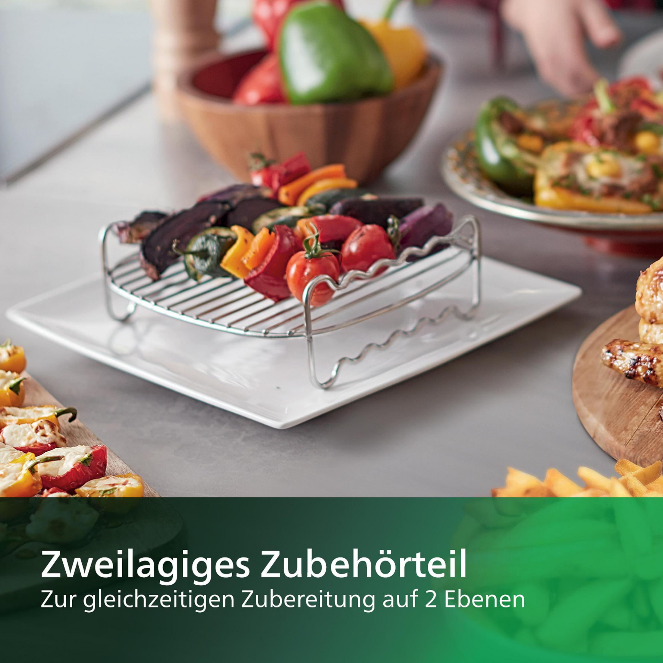 Gegrilltes Gemüse auf einem quadratischen Teller. Paprika, Tomaten und Aubergine auf einem Metallgestell. Küche im Hintergrund.