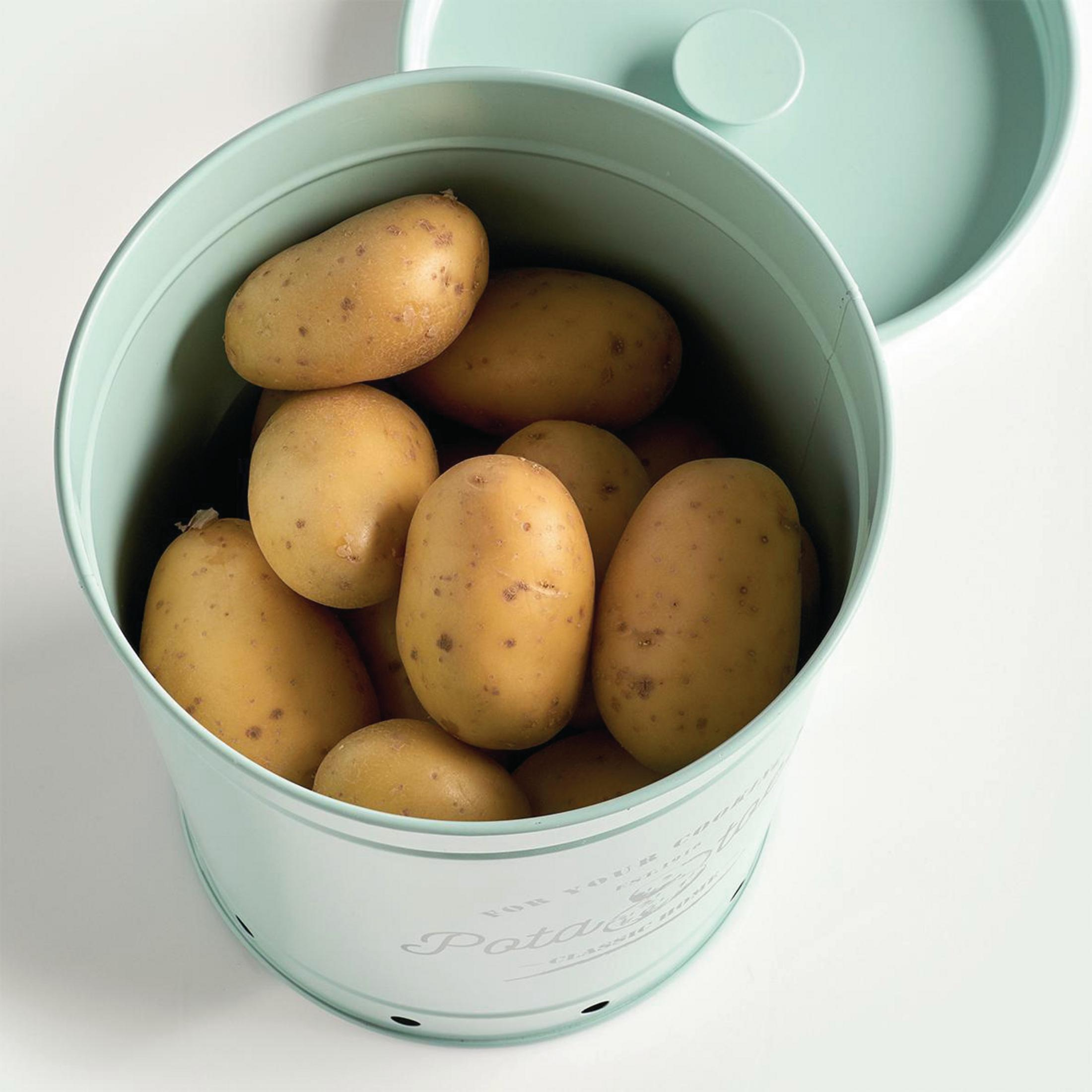 Ein hellgrüner Kartoffelbehälter aus Metall, gefüllt mit Kartoffeln, mit leicht geöffnetem Deckel.