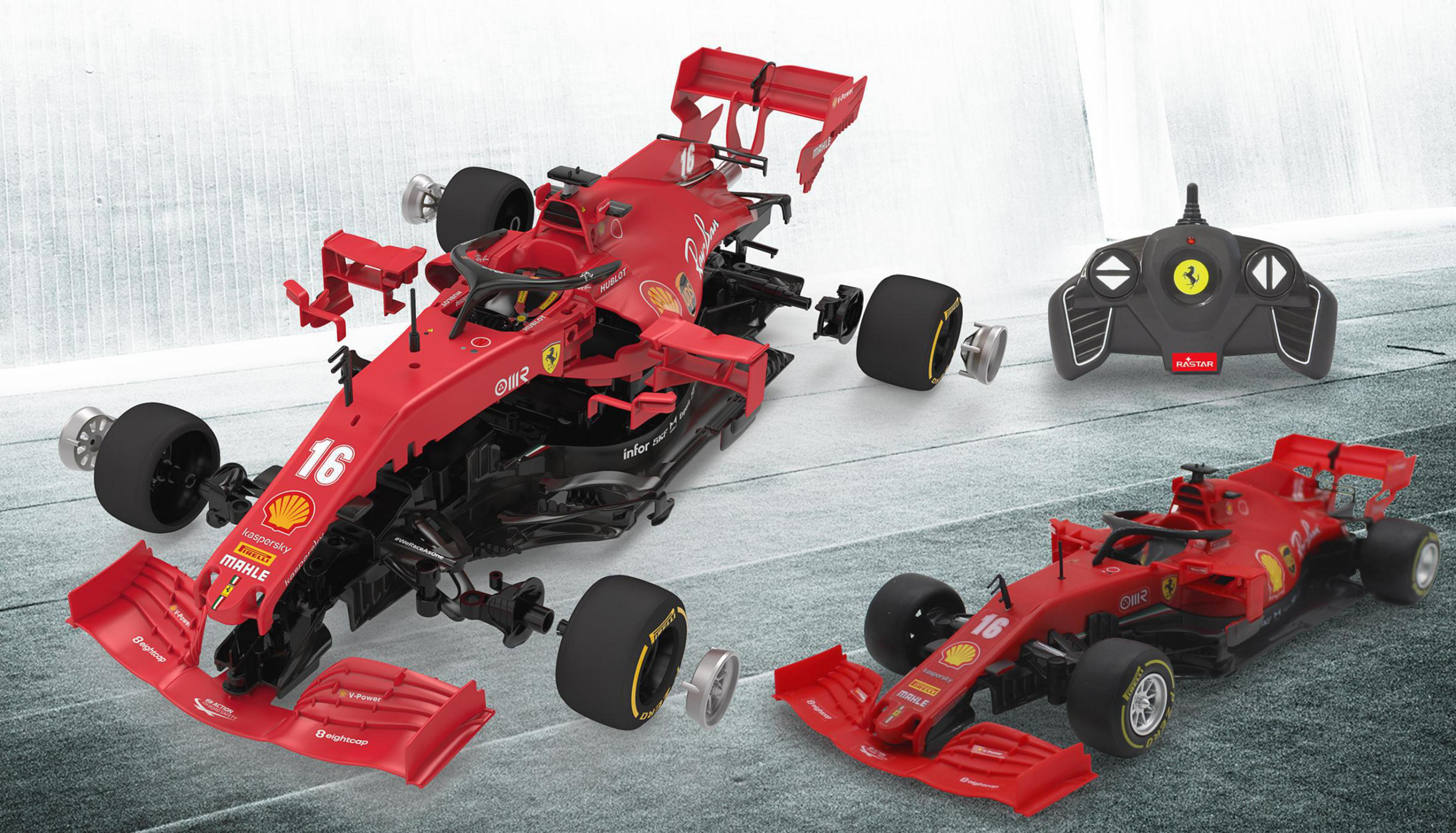 Ein zerlegtes rotes Rennwagenmodell mit Fernbedienung und Ferrari-Logo, auf dunkler Oberfläche.