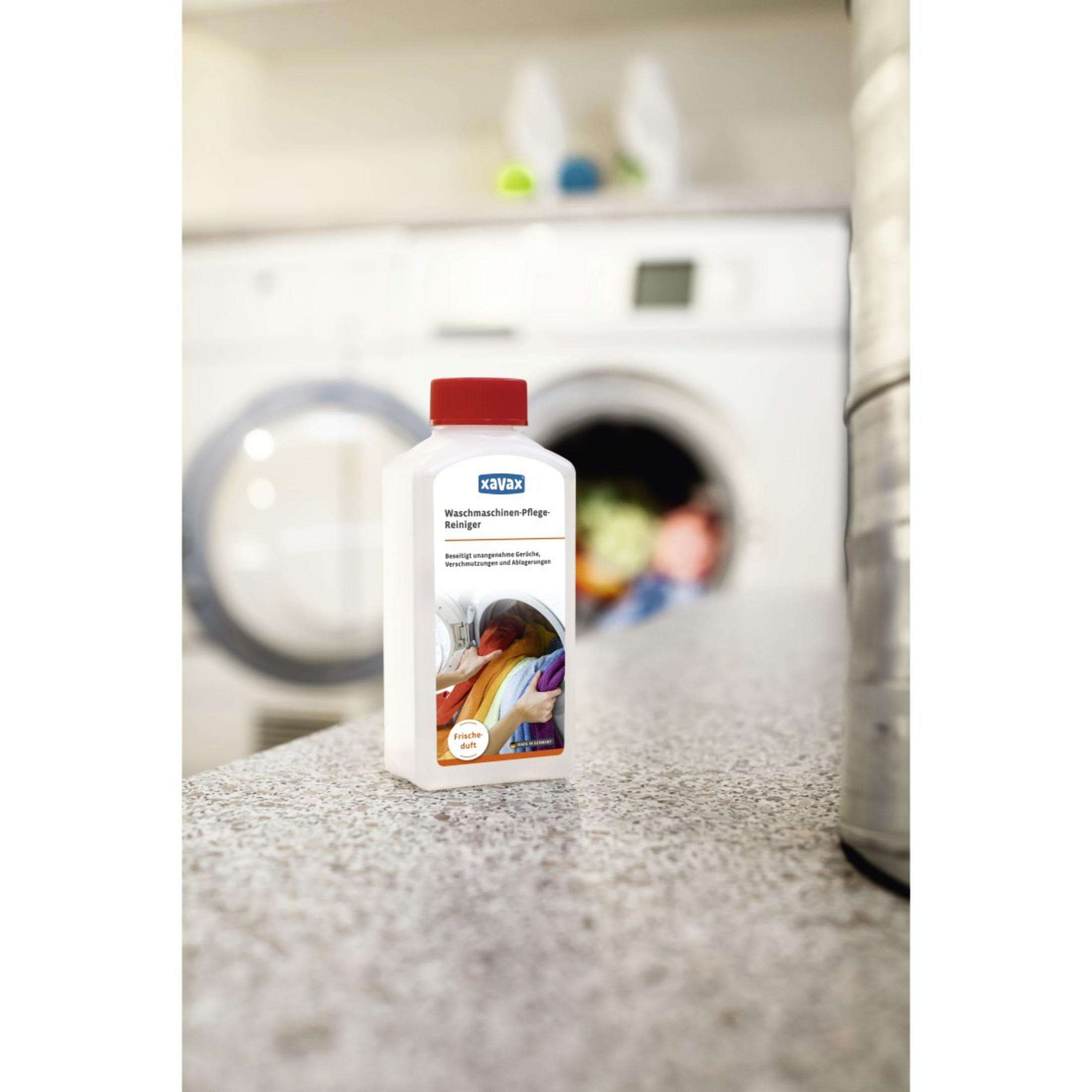 Flacone bianco di detersivo con tappo rosso. Lavatrice e cesto della biancheria sullo sfondo.