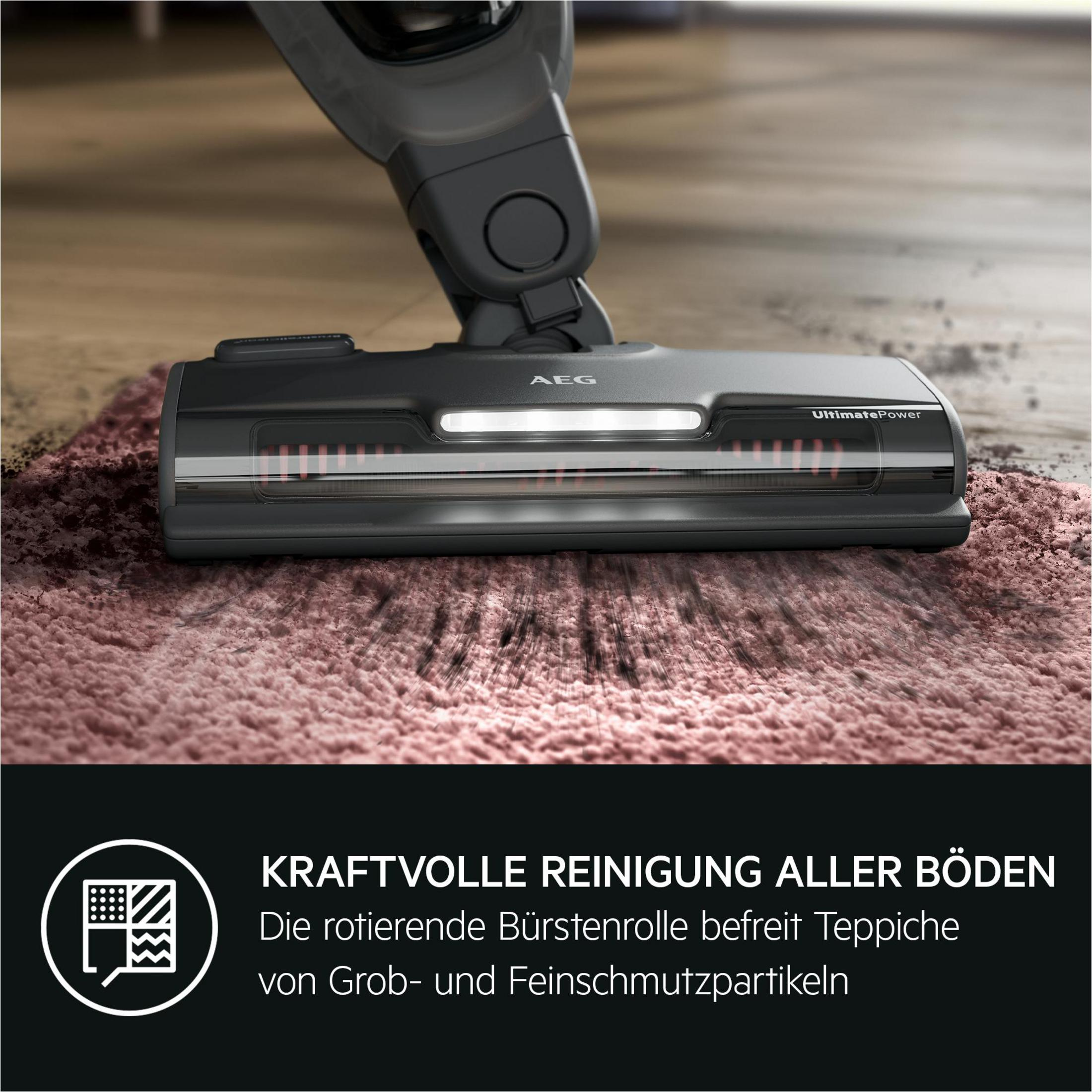 Staubsauger-Bürstenkopf auf rosa Teppich.