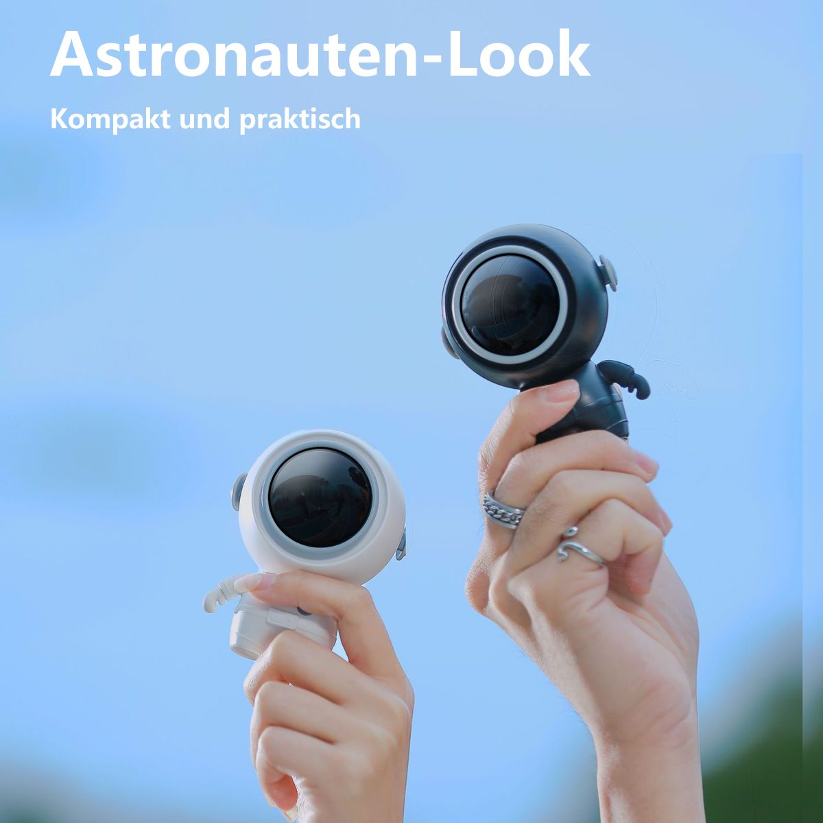 Dos altavoces pequeños con forma de astronauta. Uno blanco, uno negro.