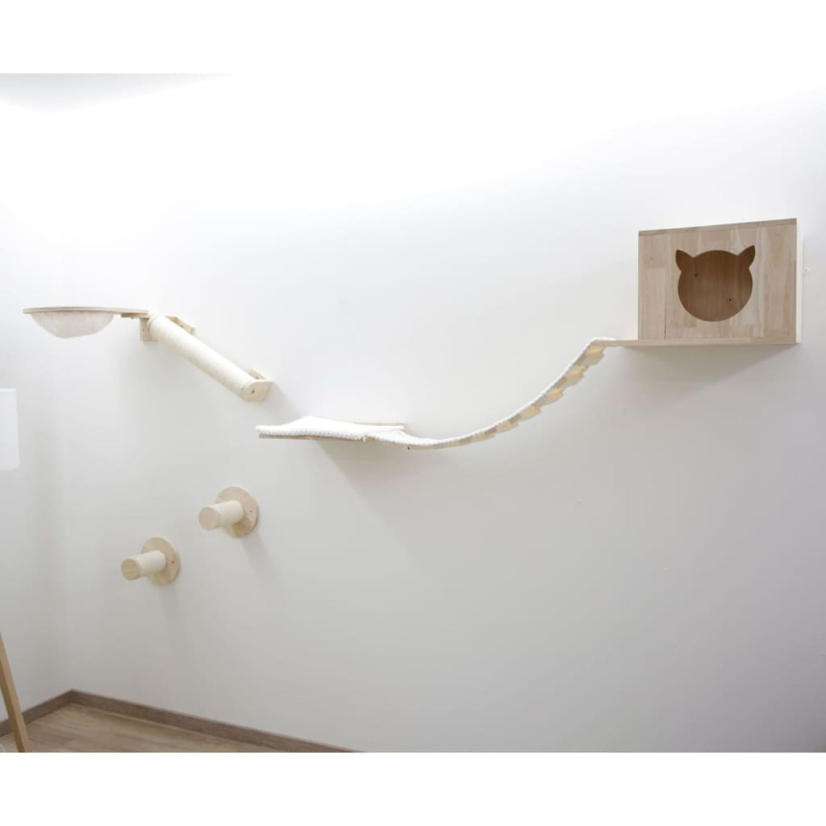 Katzenwandmöbel: Plattformen, Brücke, Haus und Stufen, alles helles Holz, an weißer Wand montiert.
