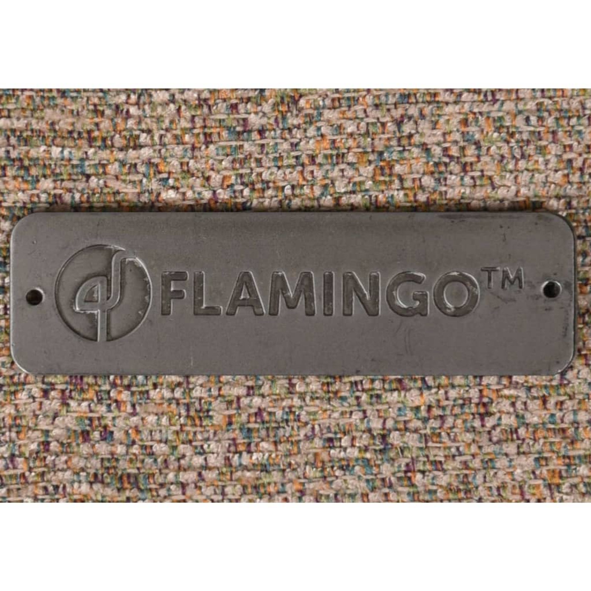 Nahaufnahme eines Metallschilds mit dem Wort 'FLAMINGO' auf Stoffhintergrund.