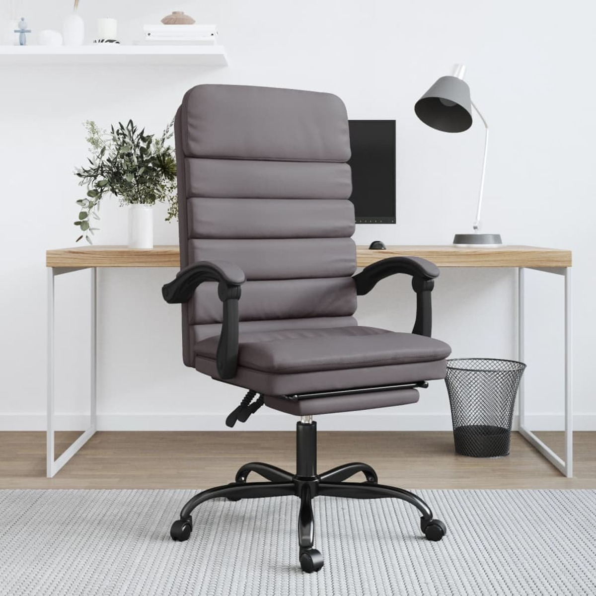 Grauer Bürostuhl mit schwarzem Gestell und Rollen; Schreibtisch, Lampe und Mülleimer.