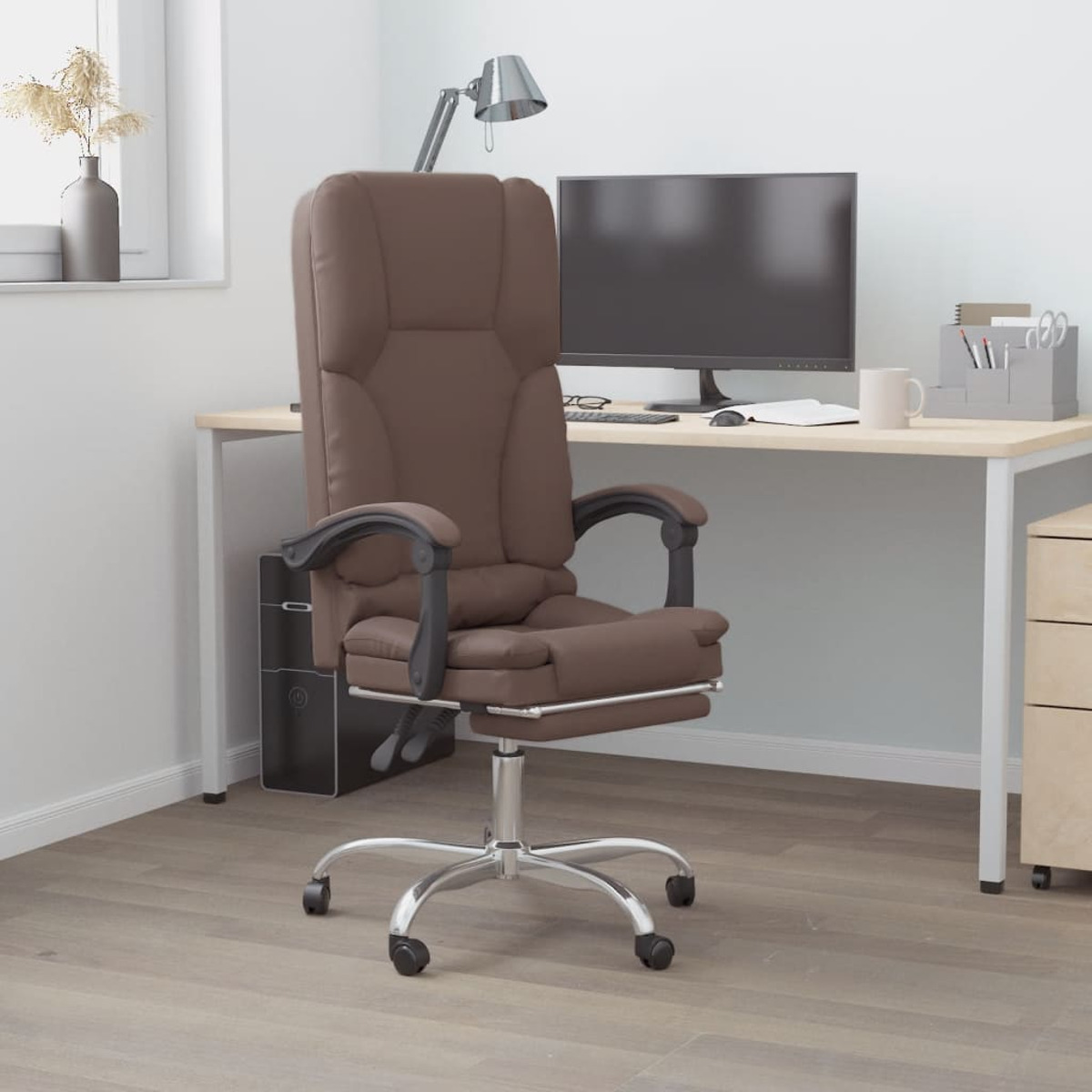 Brauner Leder-Bürostuhl mit schwarzen Armlehnen und silbernem Fuß. Im Hintergrund ein Schreibtisch, Computer und Lampe.
