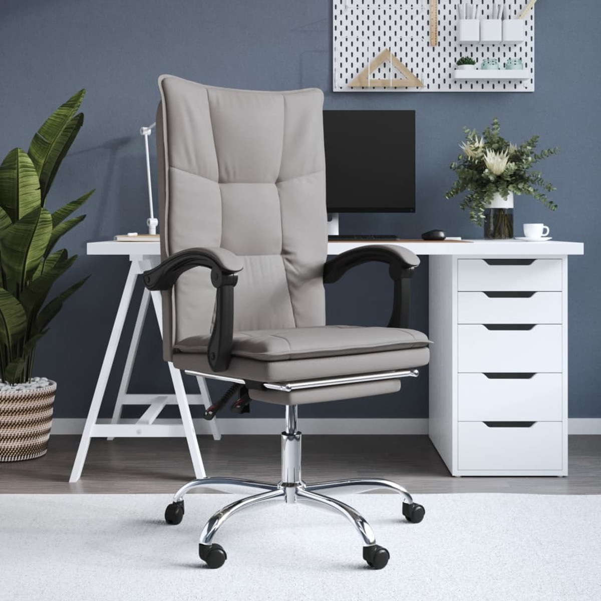 Ein Büro mit einem grauen Stuhl, einem weißen Schreibtisch mit Computer und einer Pflanze.