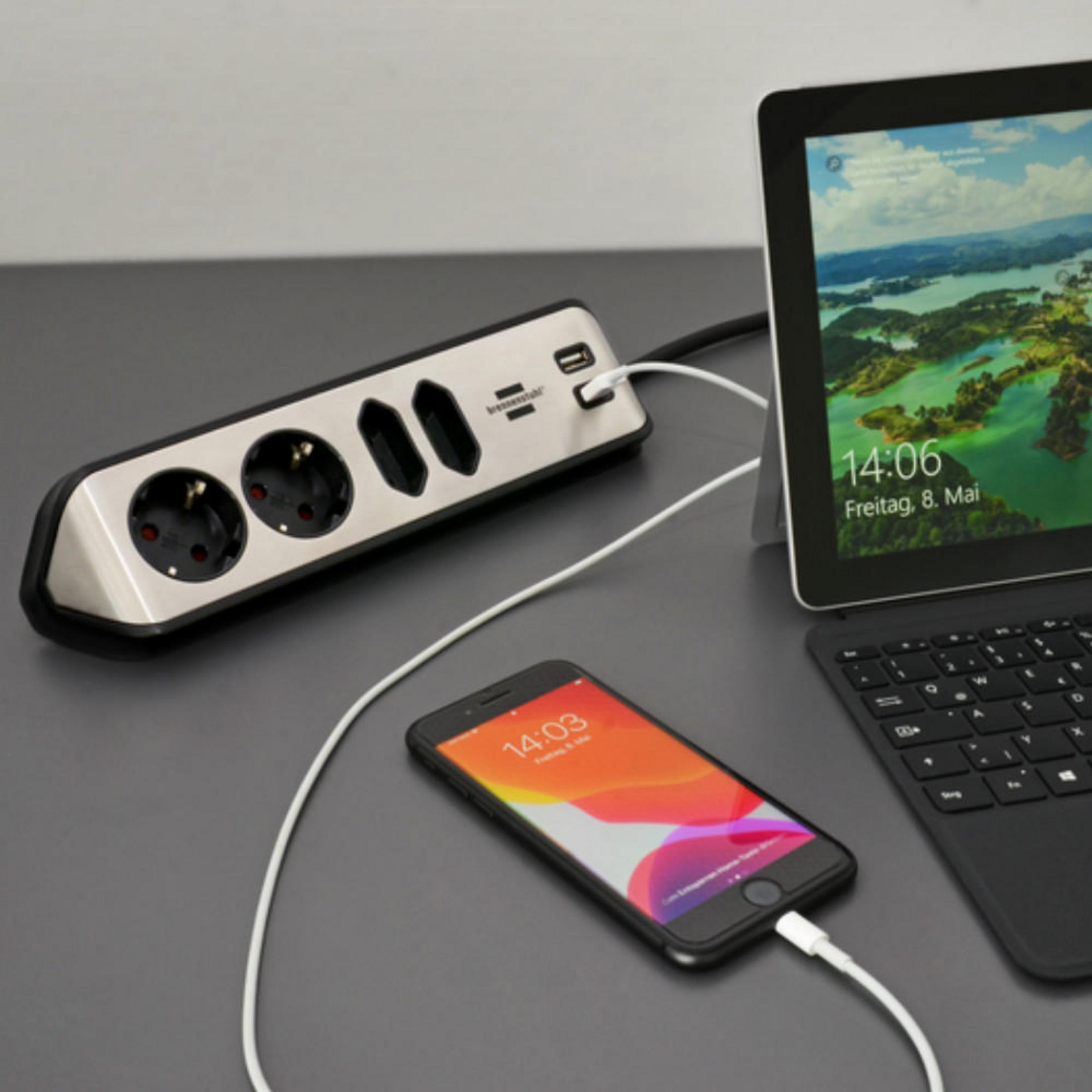 Eine Steckdosenleiste mit mehreren Steckdosen, USB-Anschlüssen und einem ladenden Telefon.