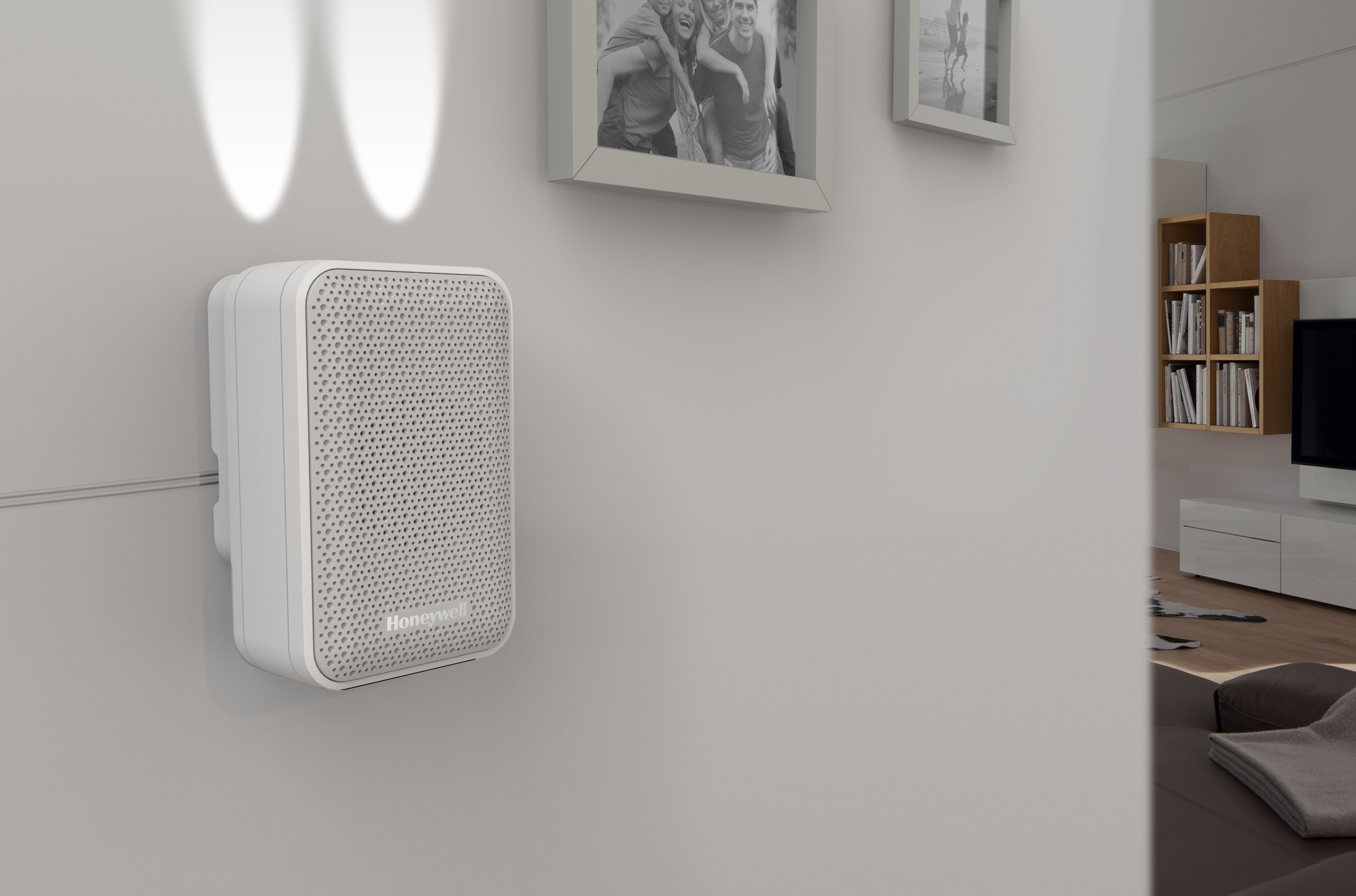 Weißes Honeywell-Sicherheitsgerät an weißer Wand. Zwei Scheinwerfer darüber. Verschwommener Hintergrund.