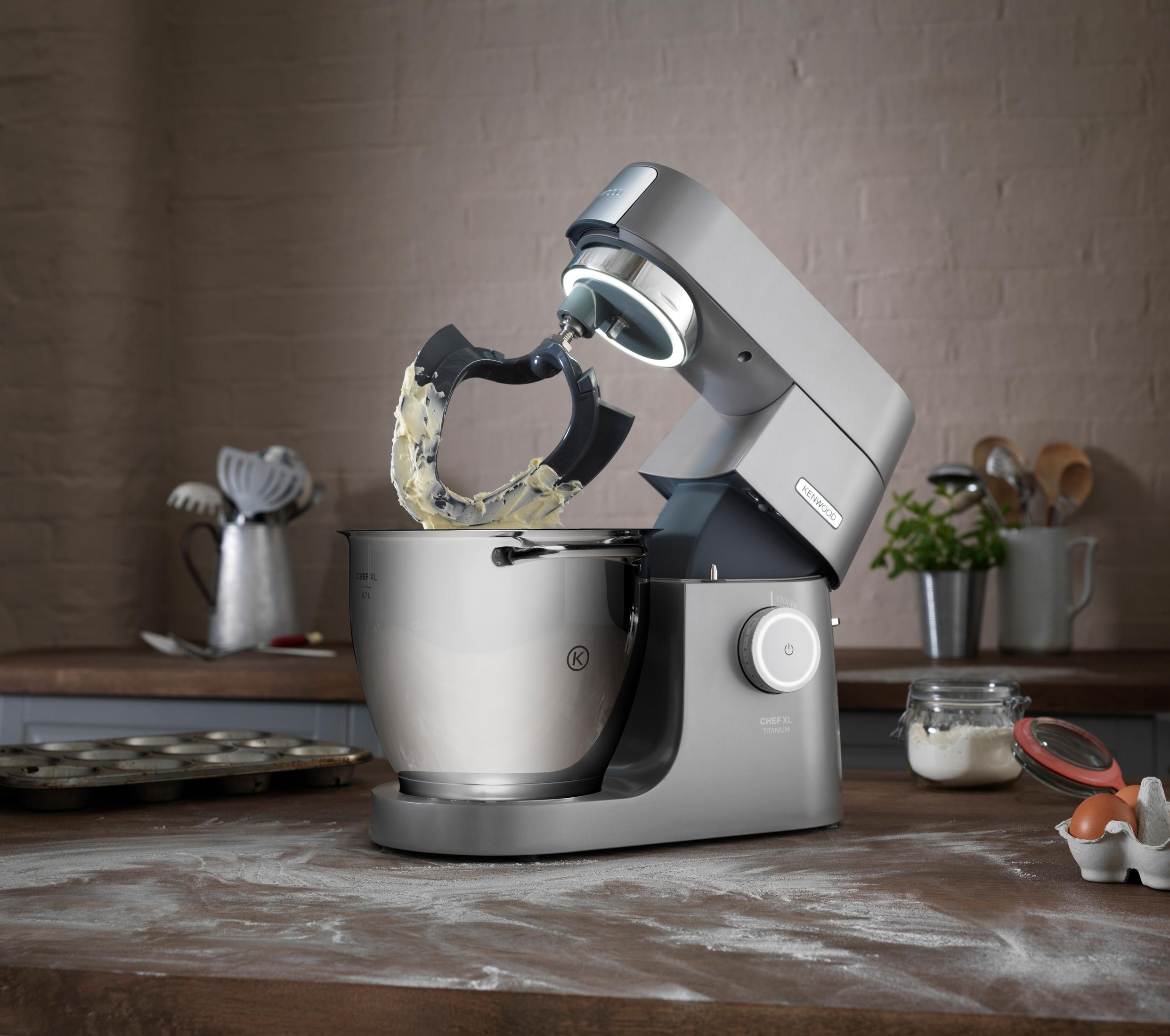 Un'impastatrice KitchenAid grigia con ingredienti sul bancone.