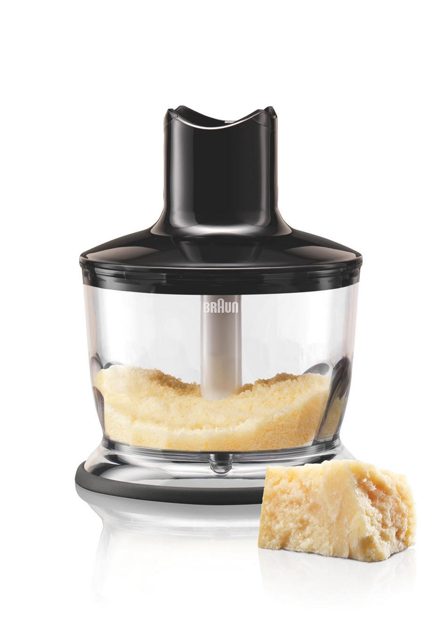 Schwarzer Braun-Handmixer in einem transparenten Behälter mit geriebenem Käse und einem Käseblock.