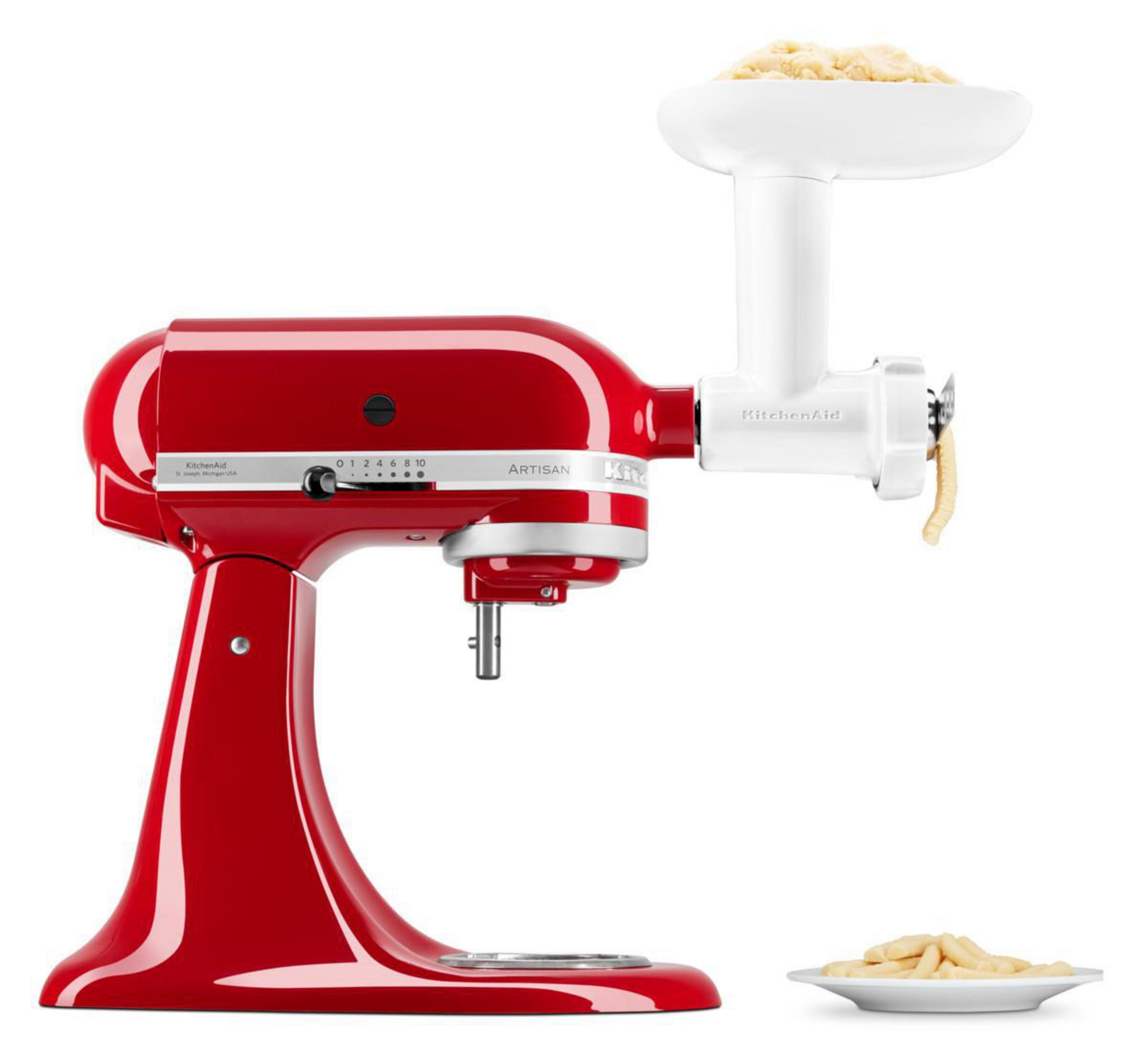Roter KitchenAid-Küchenmixer mit weißem Fleischwolfaufsatz, Nudeln auf einem Teller.