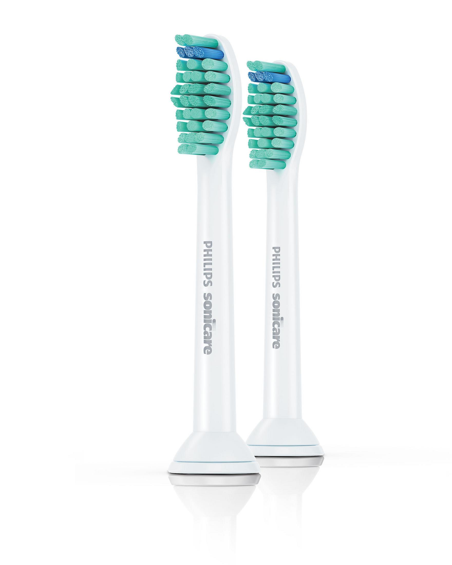 Dos cabezales de cepillo de dientes Philips Sonicare blancos con cerdas verdes y azules, aislados.