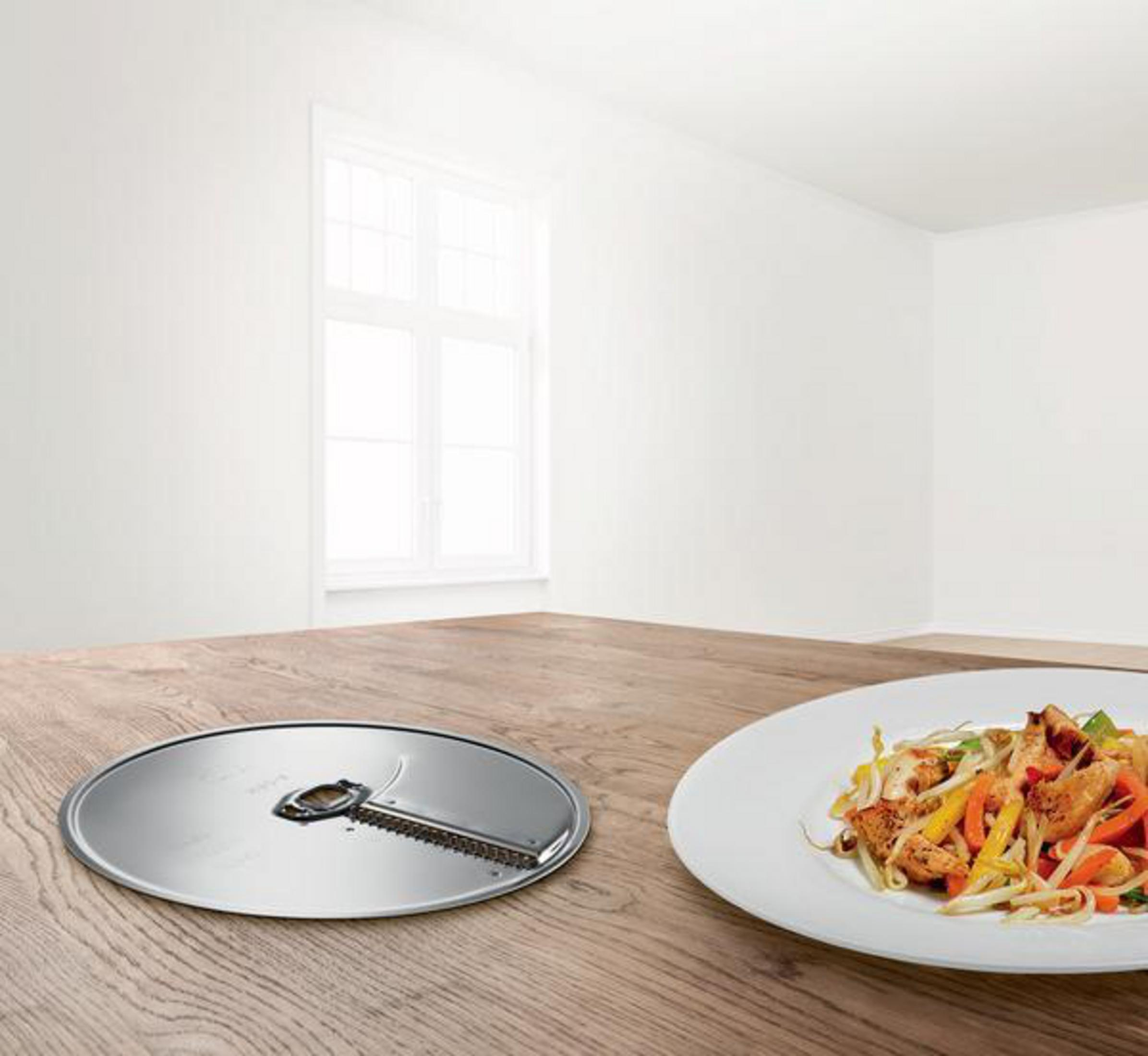 Ostrze do krojenia z daniem z patelni na stole. Biały pokój z oknem.