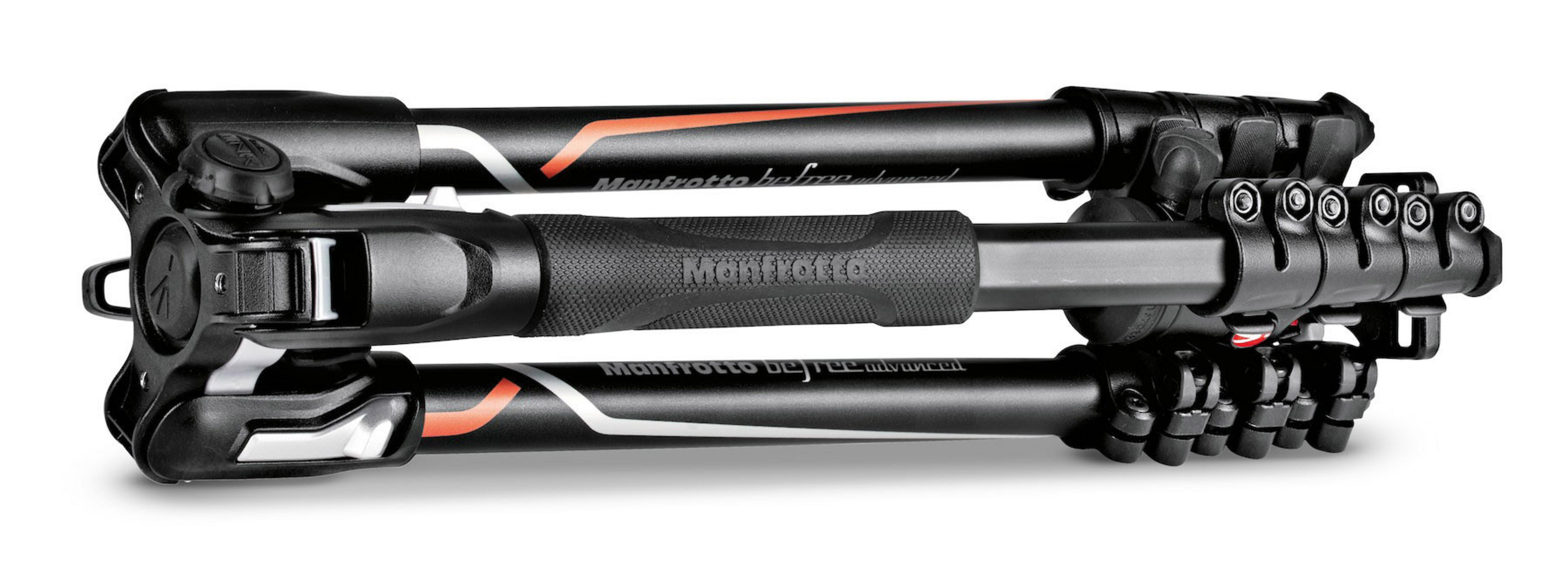 Trípode Manfrotto plegado. Negro y plateado, con detalles en naranja. Con la marca Manfrotto.