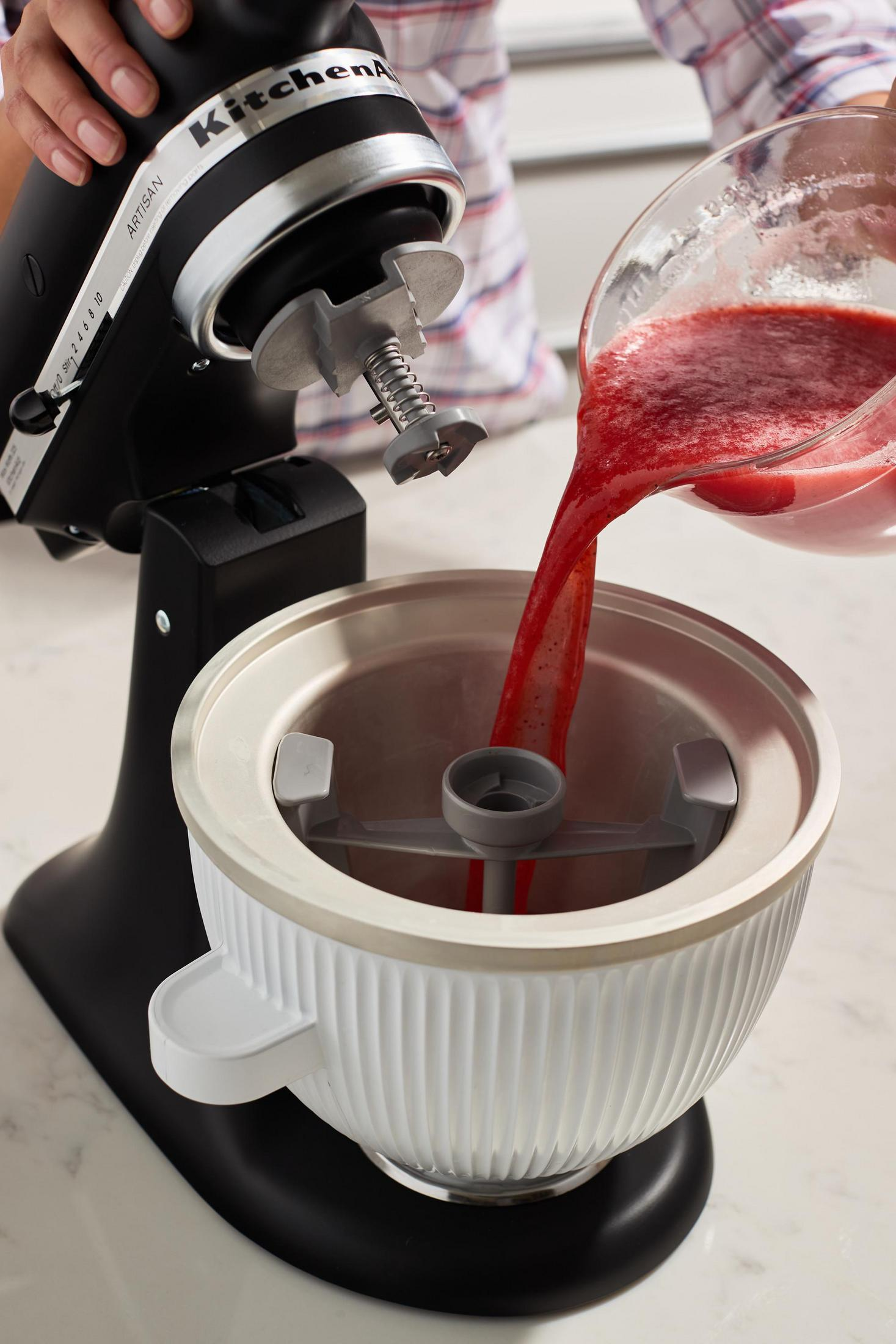 Eine KitchenAid Küchenmaschine, in die eine rote Flüssigkeit gegossen wird.