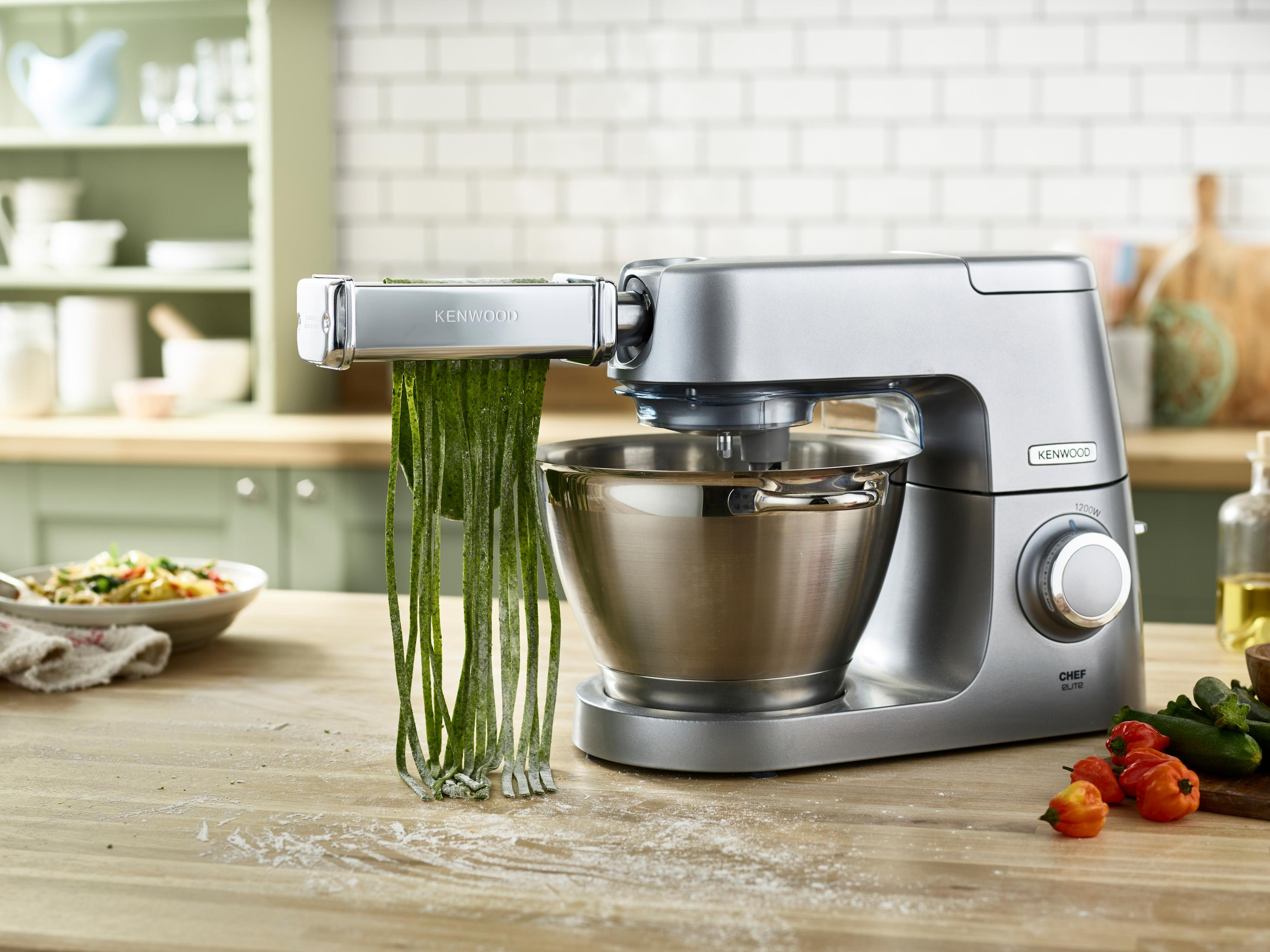 Srebrny mikser Kenwood Chef Elite z przystawką do makaronu, robiący zielony makaron.