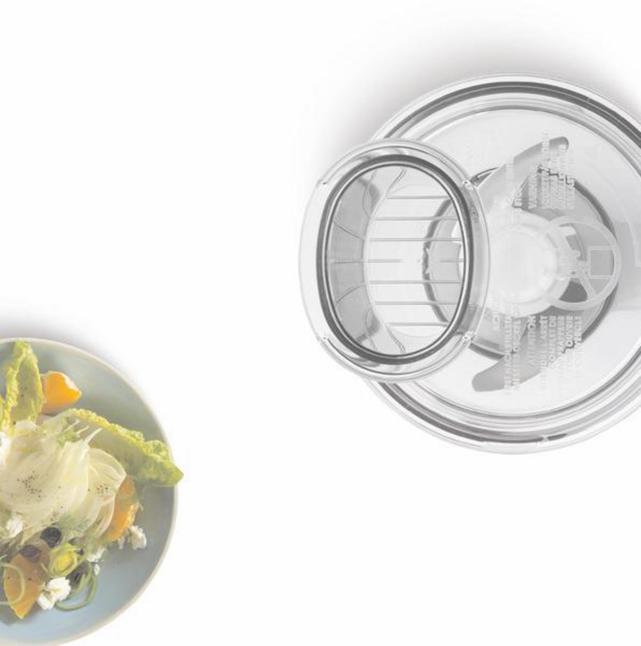 Ein Salat mit einem durchsichtigen Plastikdeckel, neben einer Salatschüssel mit hellblauem Rand.
