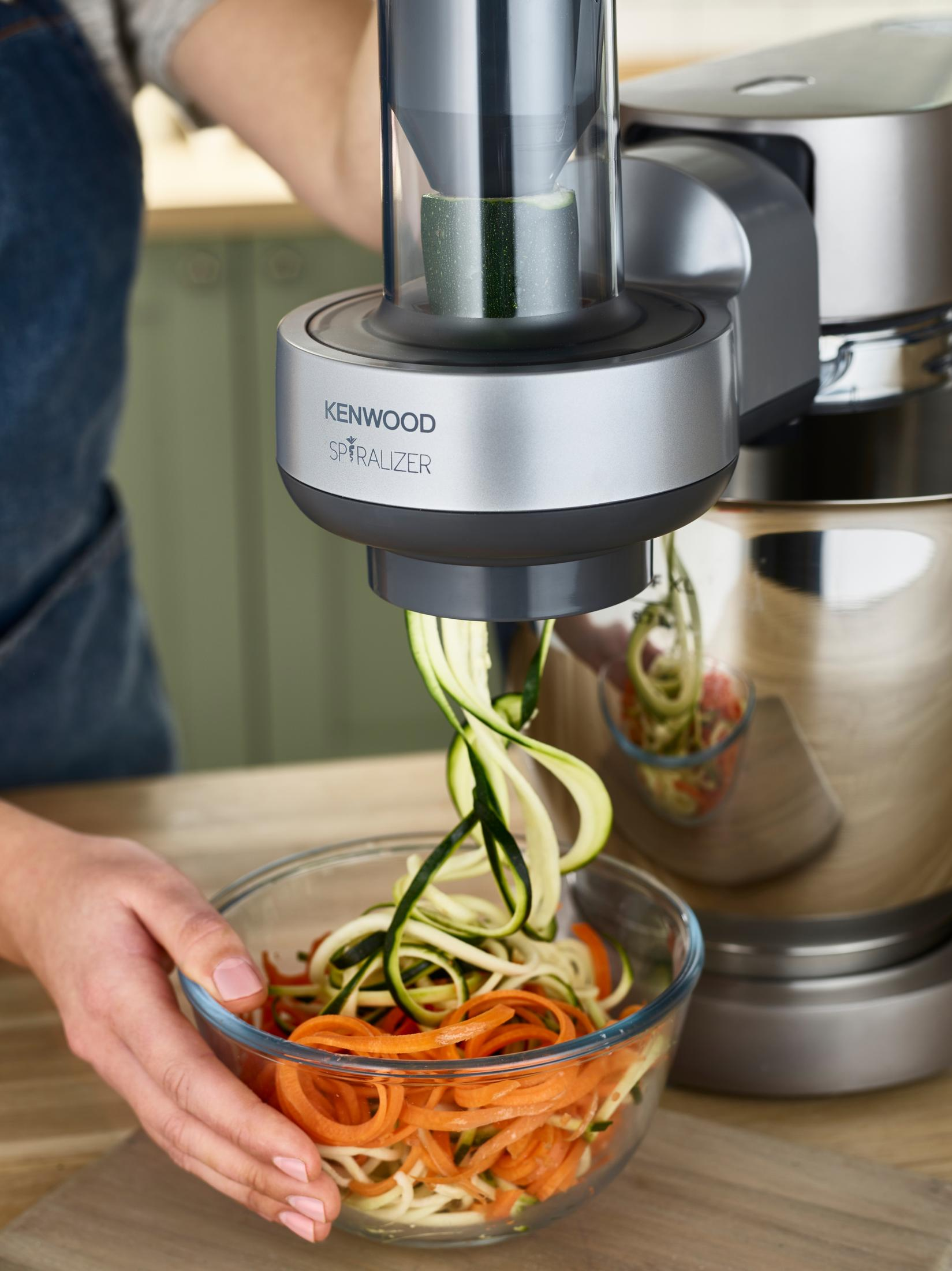 Osoba używająca Kenwood Spiralizer z warzywami w misce. Tło jest rozmyte.