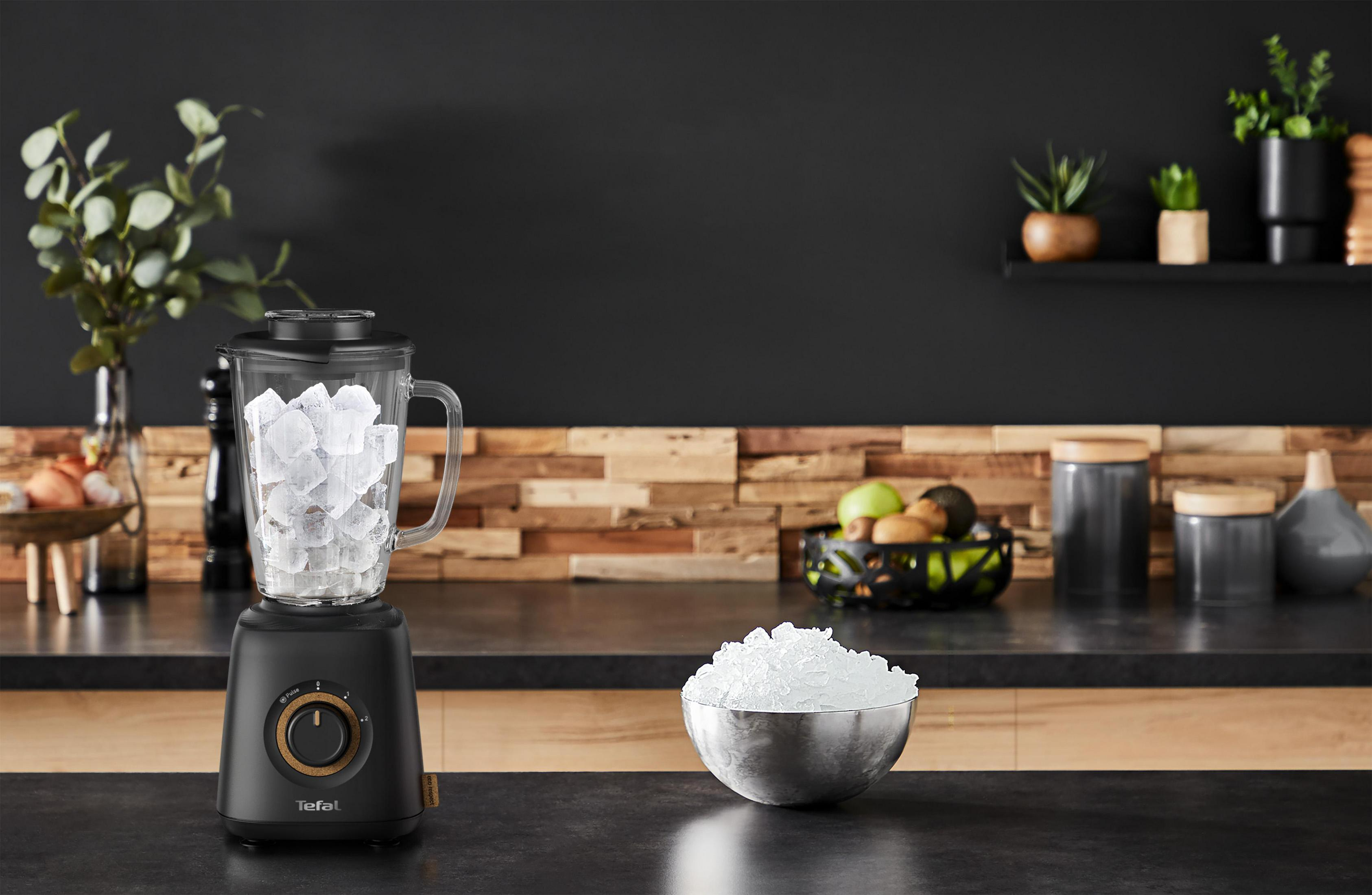 Schwarzer Mixer mit Eiswürfeln. Eisschale auf der Theke. Dunkler Hintergrund mit Holzverkleidung.