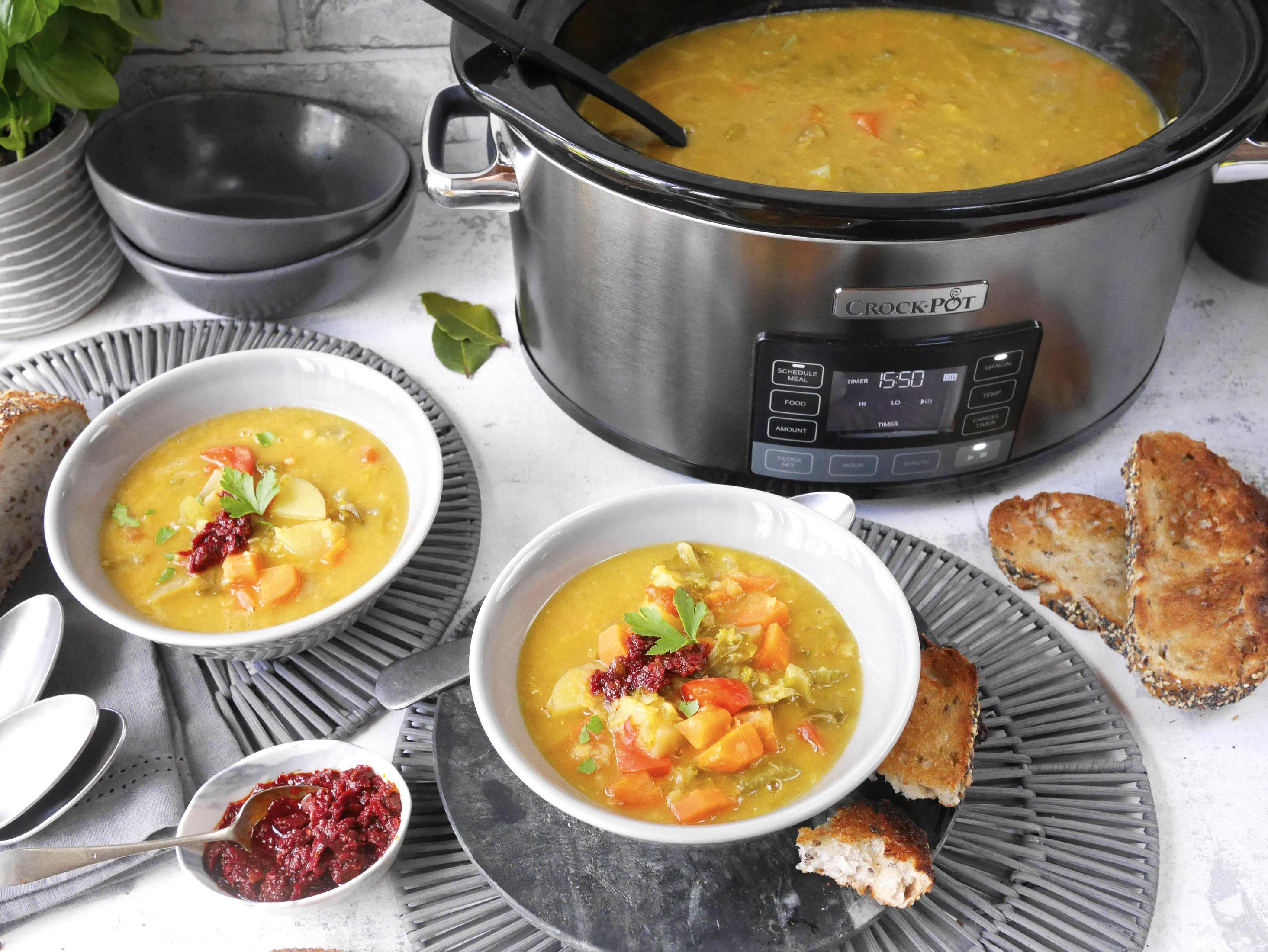 Zwei Schüsseln Suppe mit Brot und ein Schongarer. Rotes Gewürz in einer kleinen Schüssel.