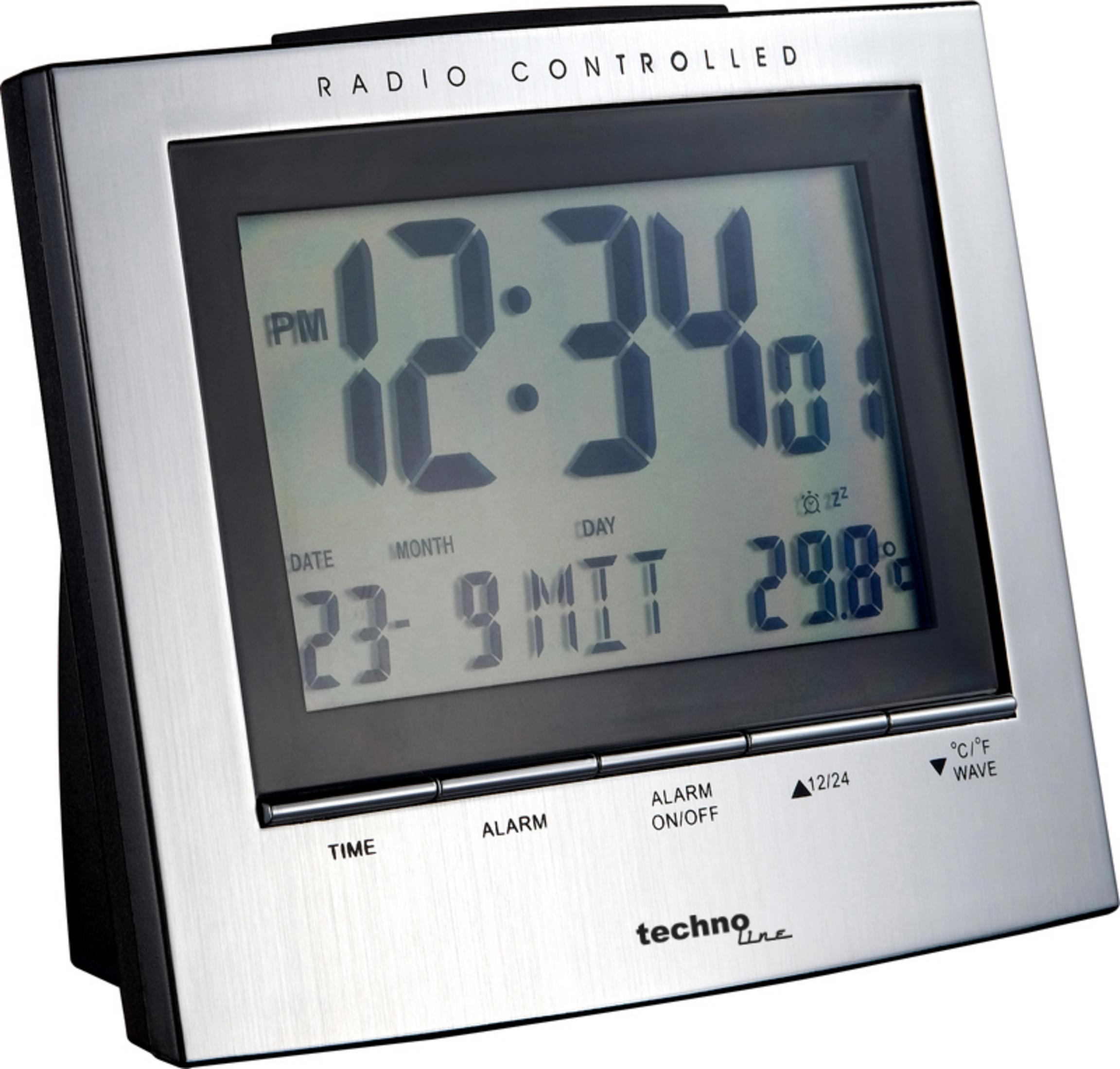 Silberne Digitaluhr zeigt 12:34 mit Datum und Temperatur. Ein schwarzer Rahmen und Sockel sind sichtbar.