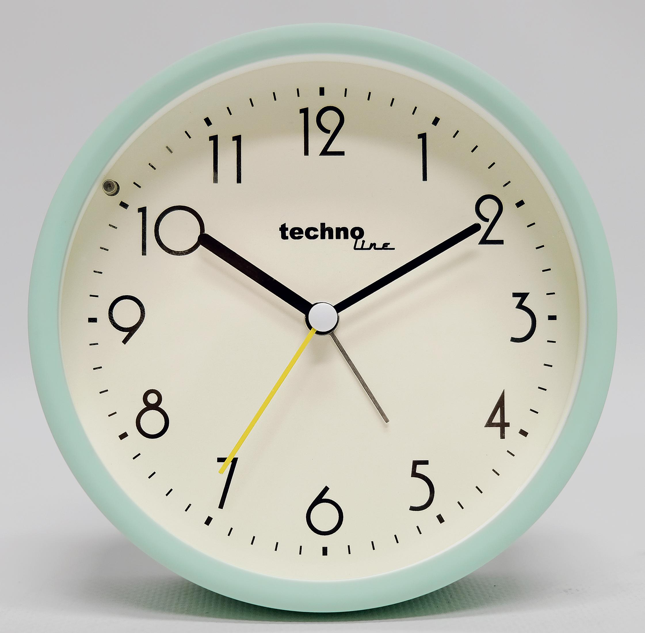 Eine mintgrüne Techno-Line-Uhr mit schwarzen Zahlen und Zeigern auf cremefarbenem Zifferblatt.