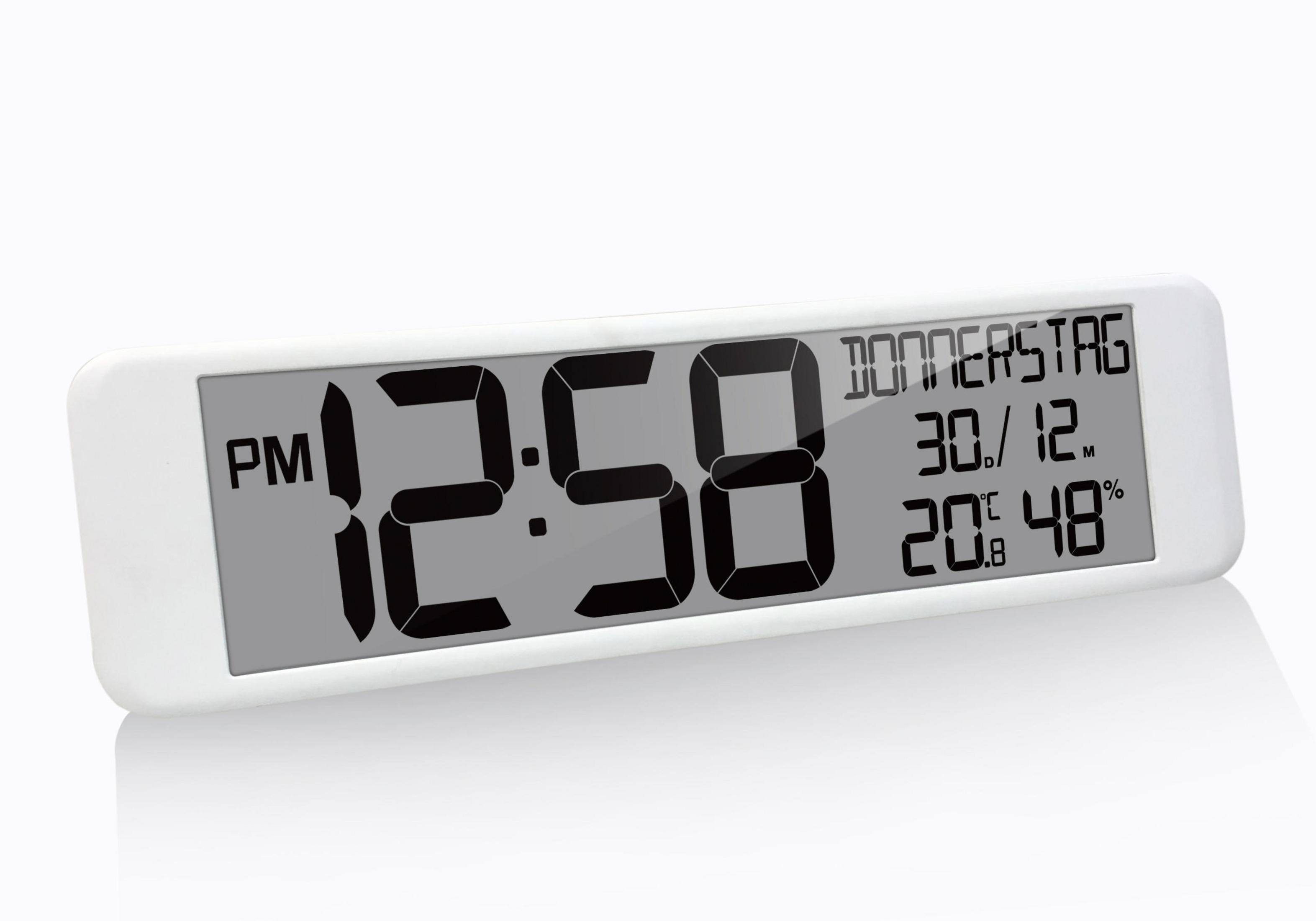 Weiße Digitaluhr. Zeigt Uhrzeit und Datum, einschließlich Wochentag. Zahlen sind schwarz auf grauem Grund.