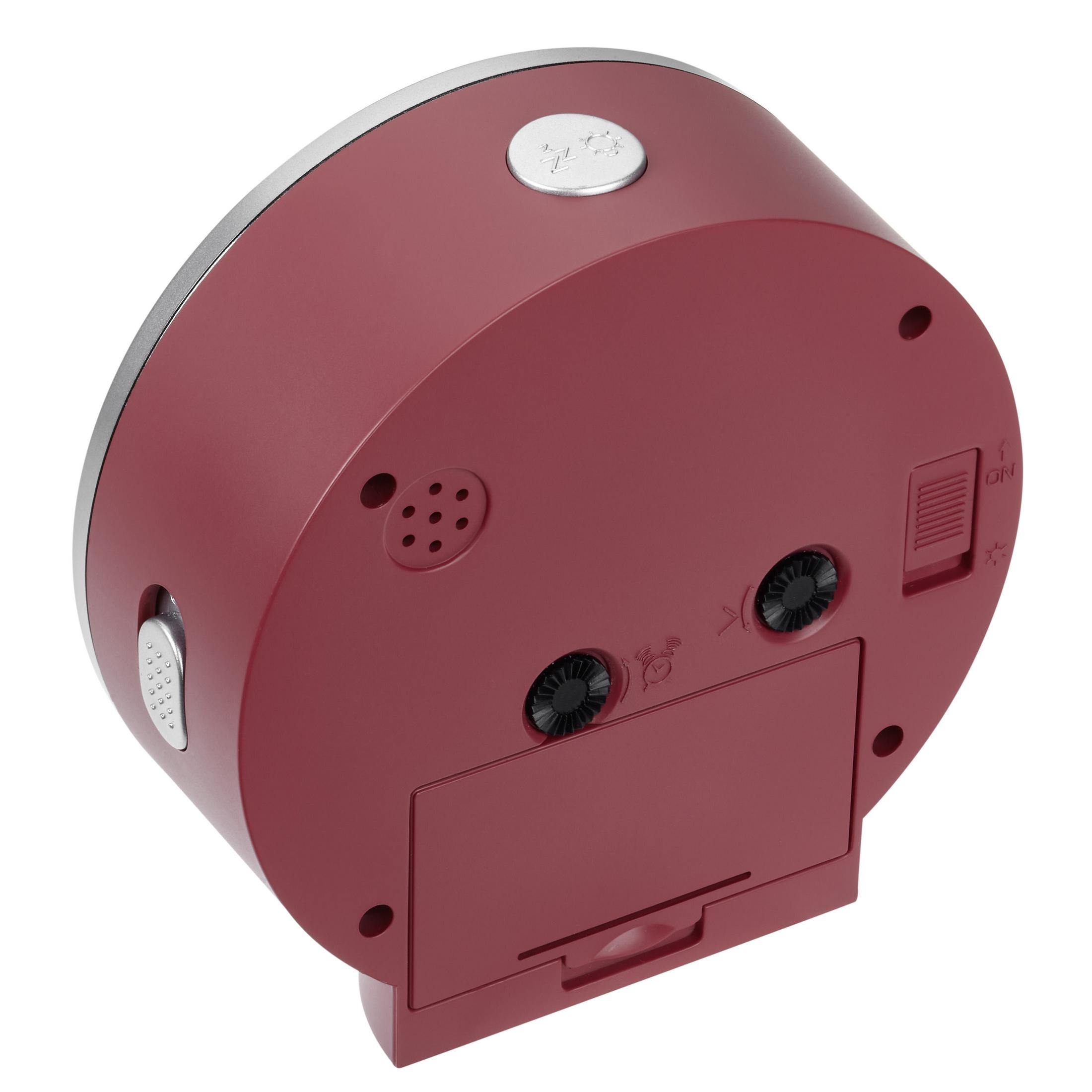 Rückseite des weinroten Weckers. Er hat einen Silberrand und einen Knopf. Die Rückseite hat Löcher, einen Stromanschluss und eine Batterietür.