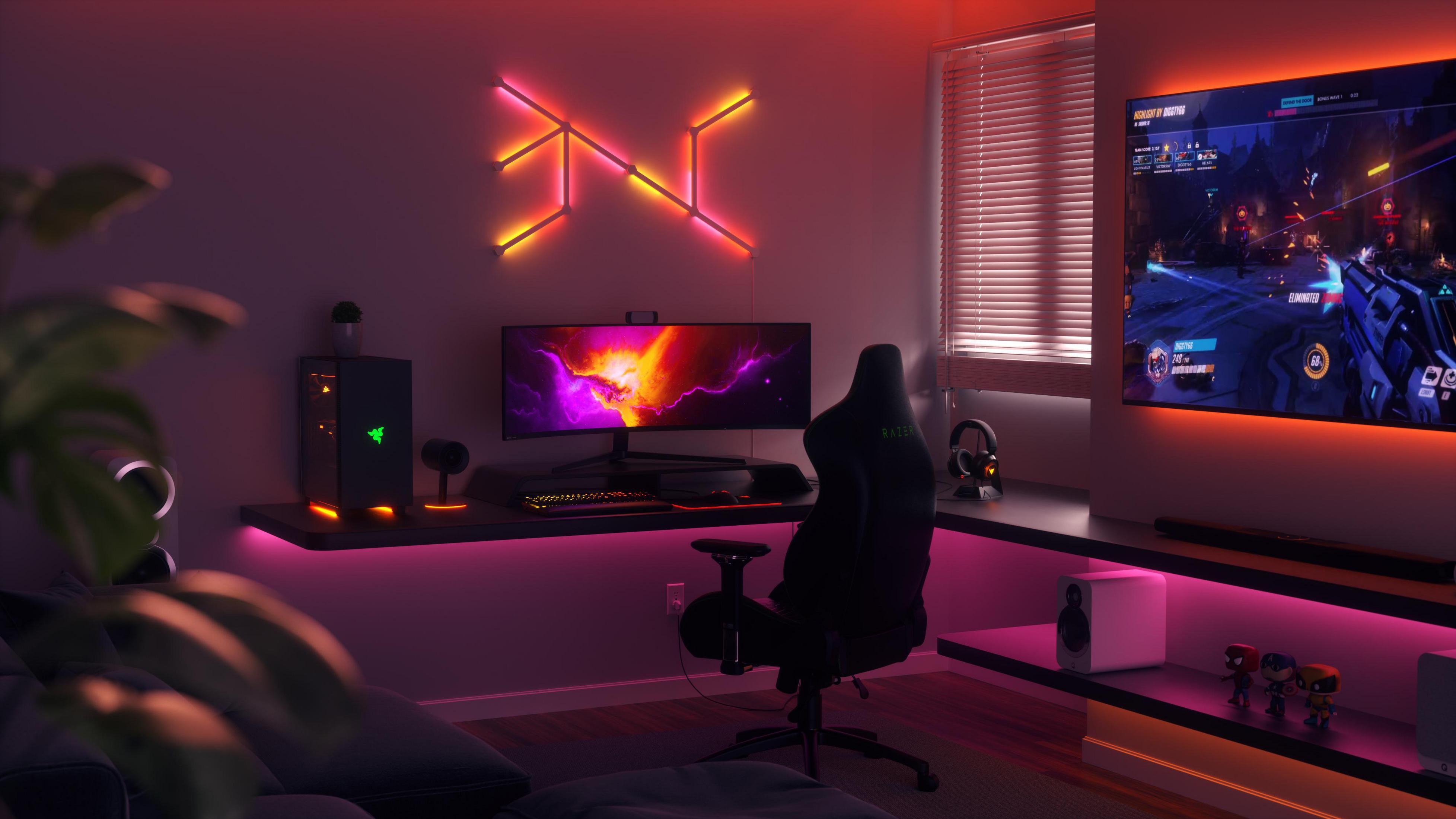 Stanza giochi con PC, scrivania, TV e luci al neon, un'attrezzatura da giocatore.