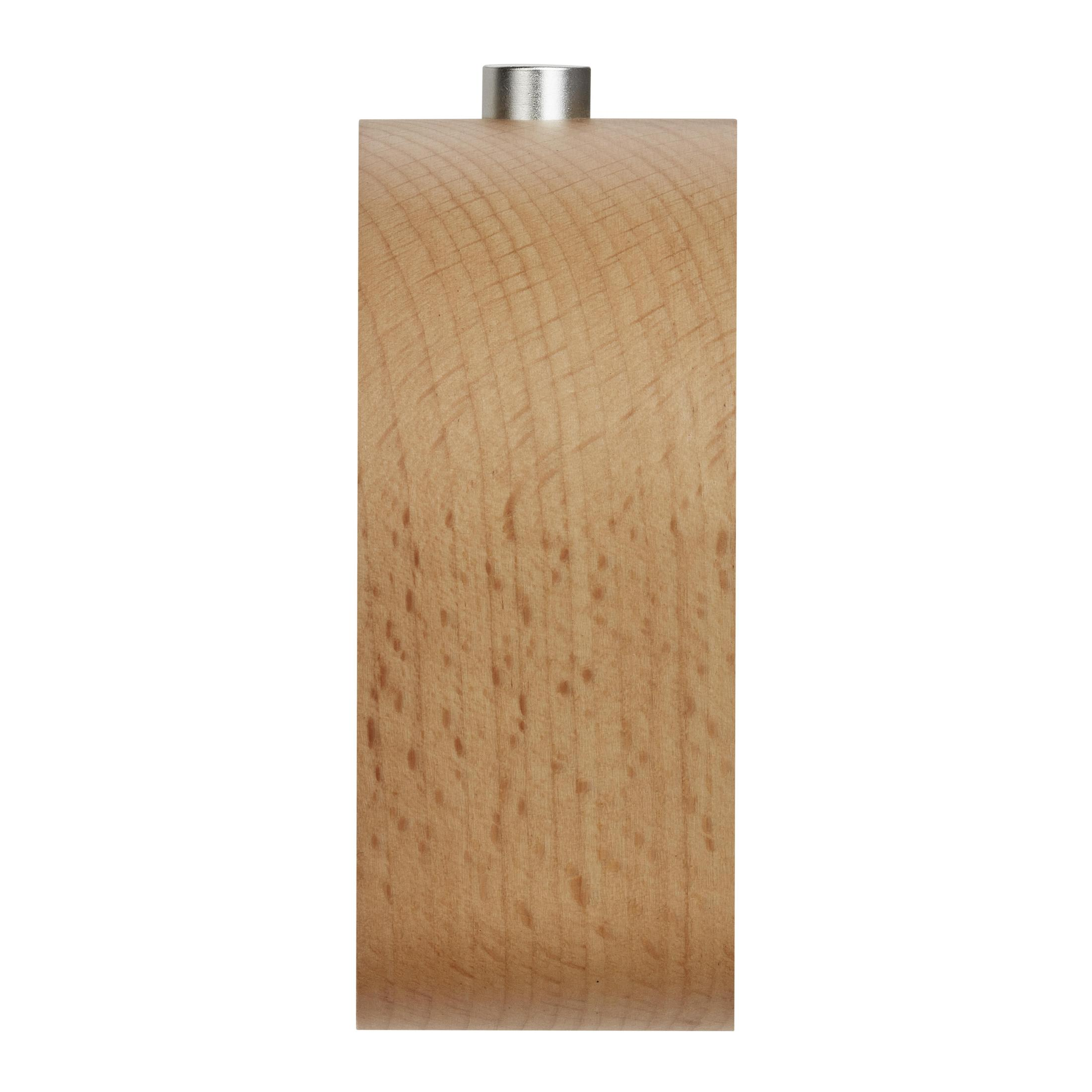 Un cylindre en bois avec un dessus argenté. Le bois est brun clair et a un grain naturel.
