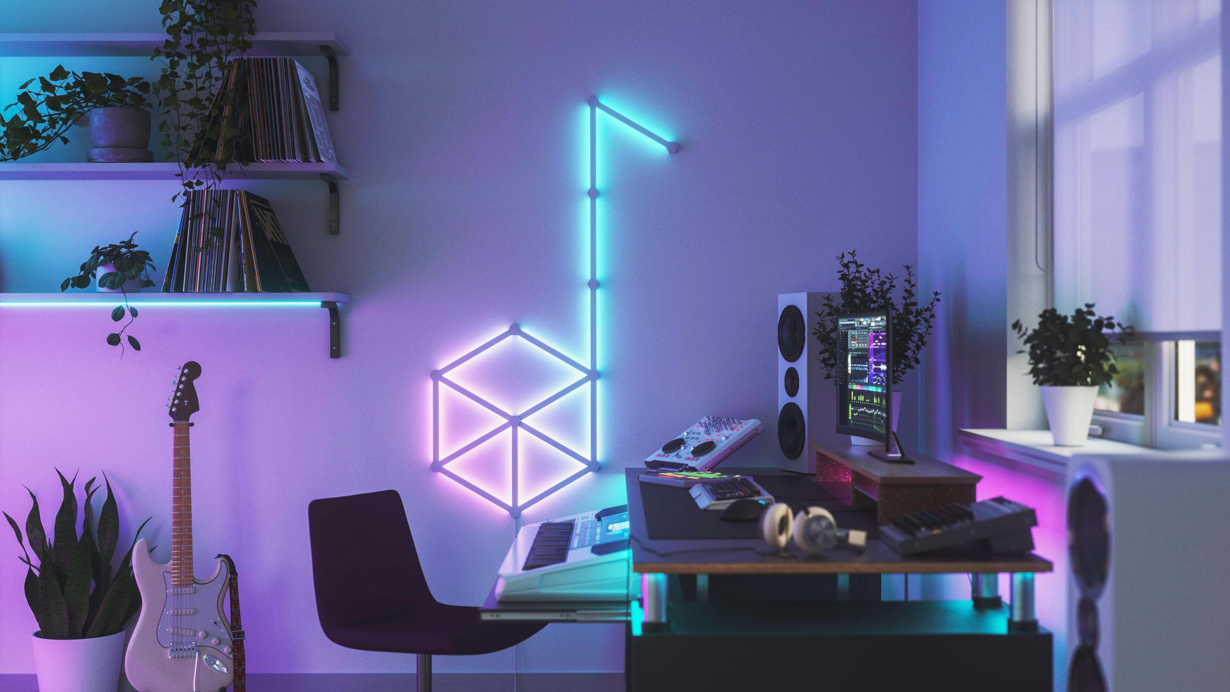 Studio musicale con luce a forma di nota, tastiere, chitarra e monitor.