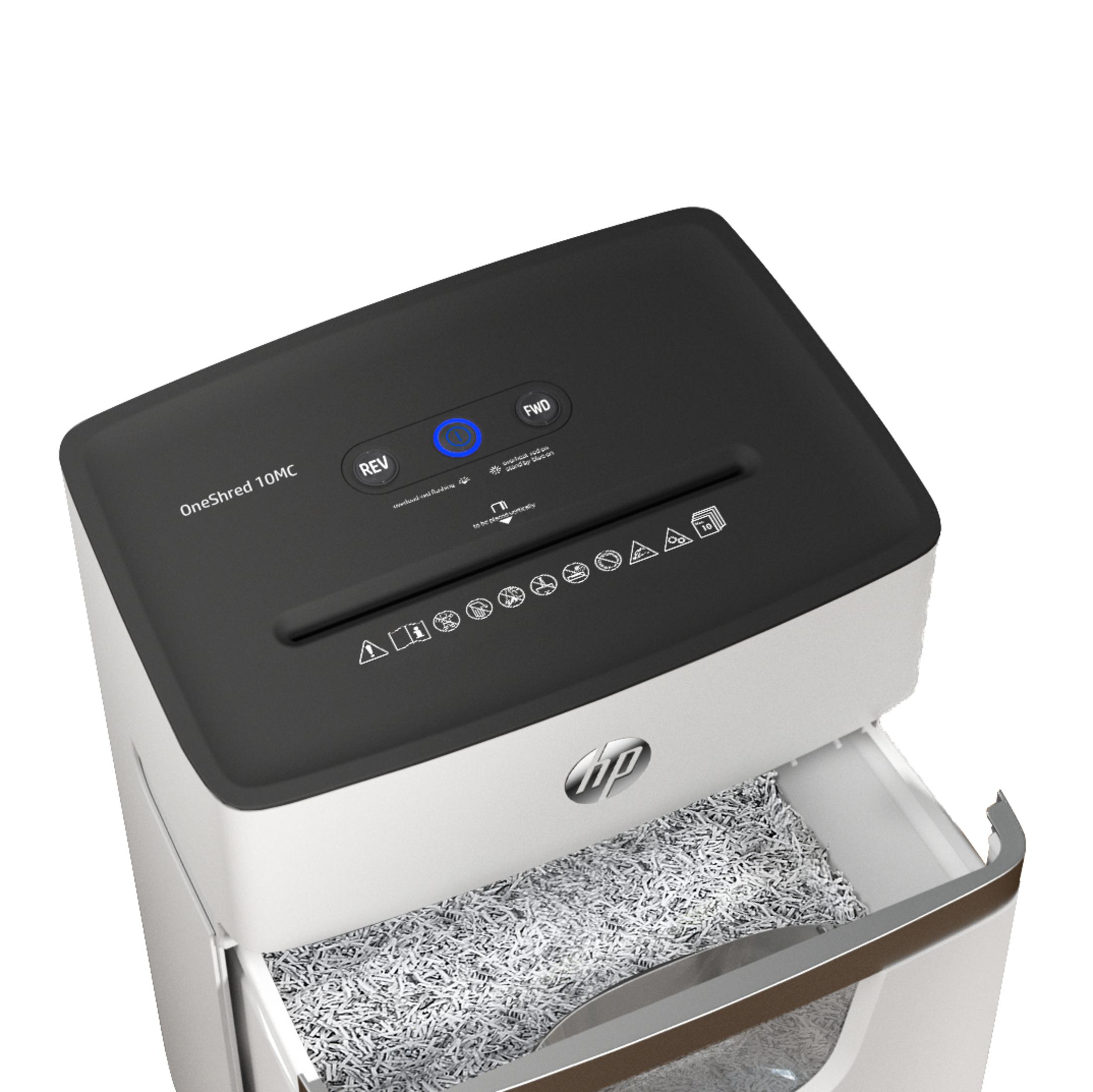 Biało-czarna niszczarka do papieru z otwartą szufladą, pełną pociętego papieru.