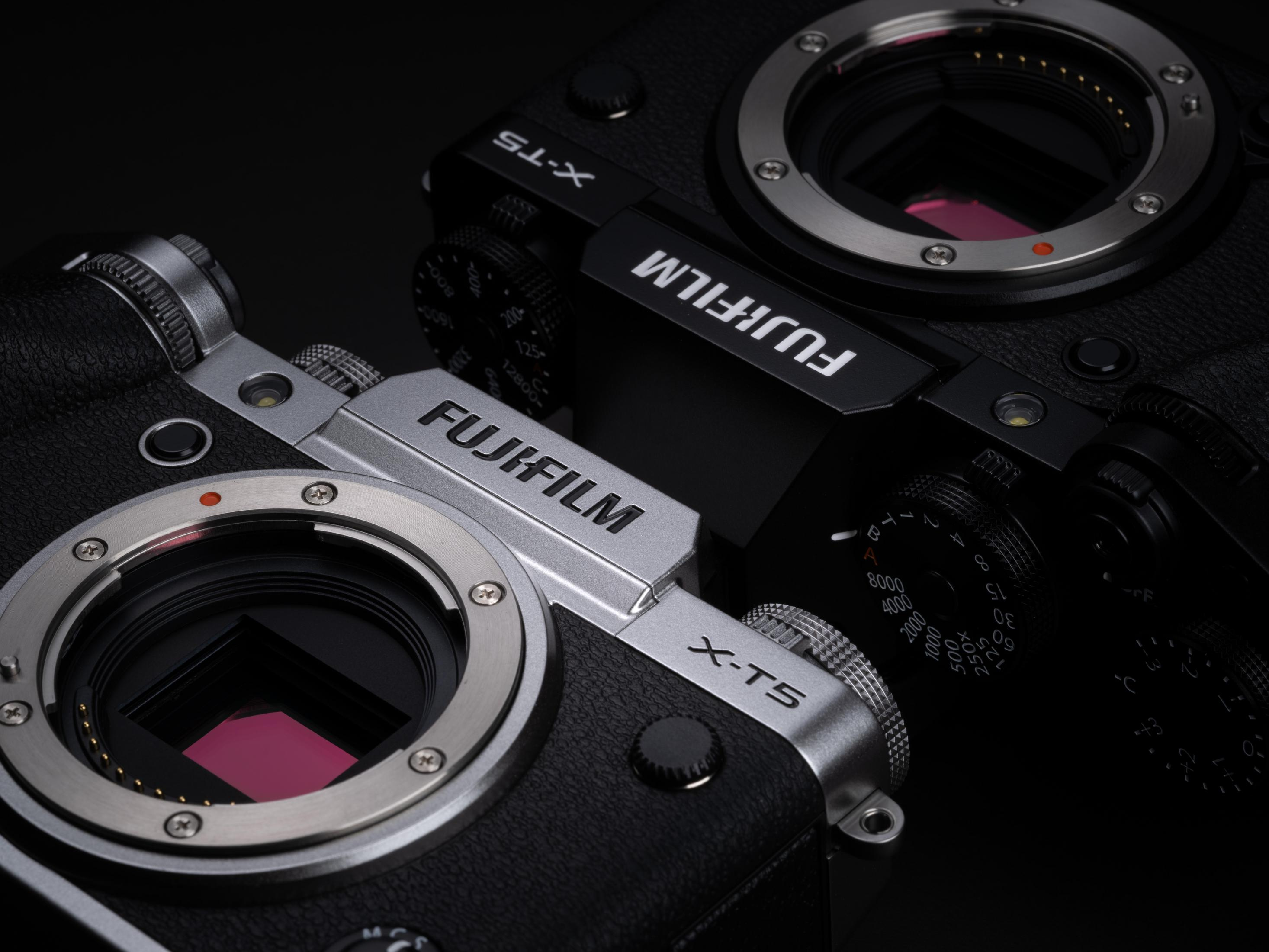 Zwei schwarze Fujifilm X-T5 Kameras, eine abgewinkelt, um den Markennamen zu zeigen.