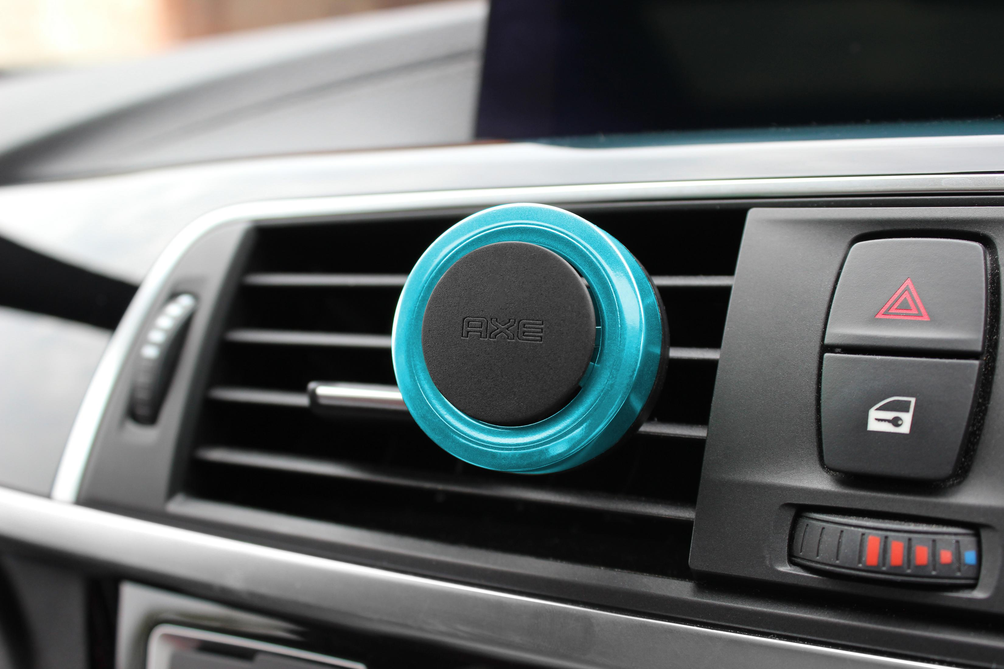 Blauer Handyhalter für die Lüftung im Auto mit schwarzem Mittelteil auf dem Armaturenbrett.
